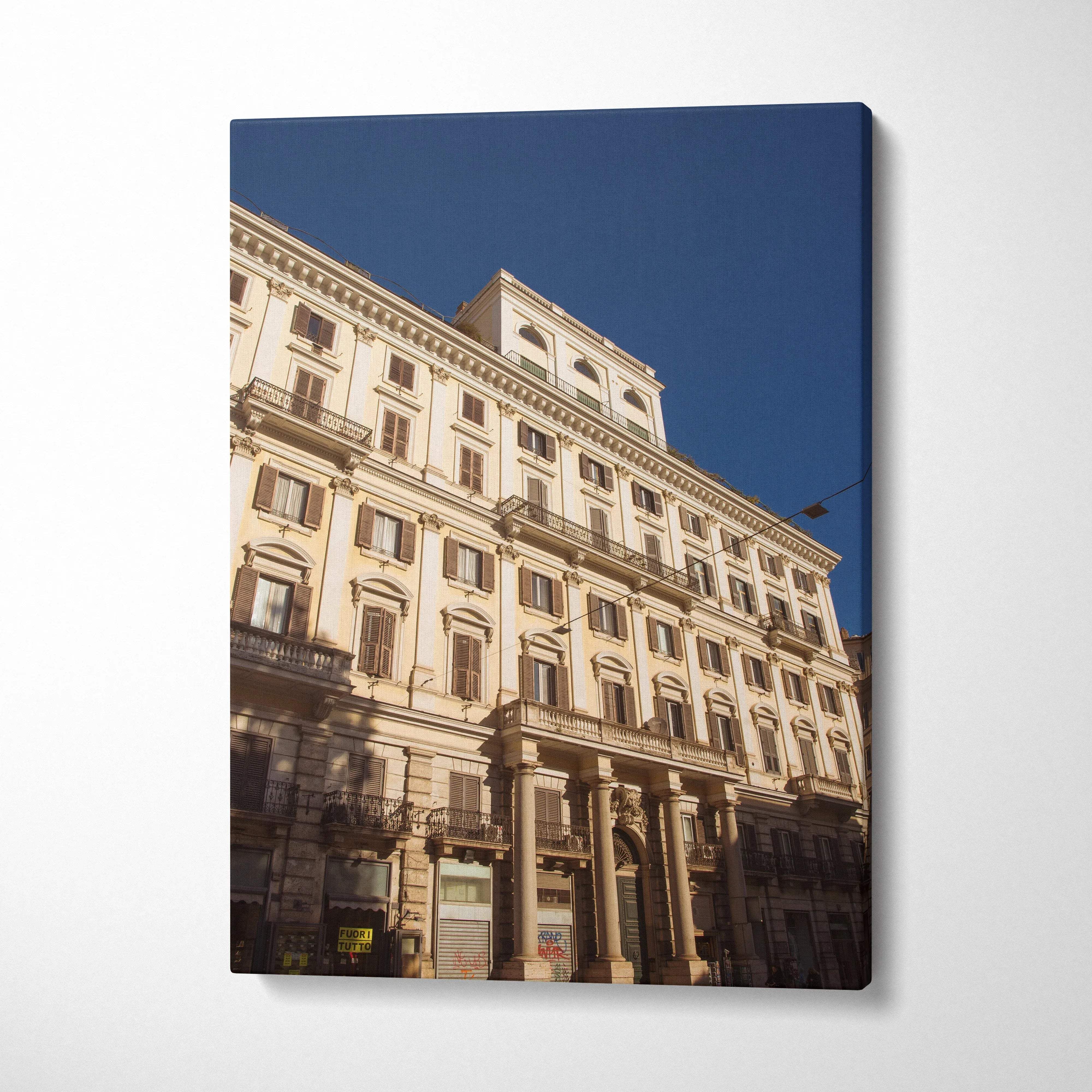 Vertical canvas wall art featuring detailed classical urban building facade against clear blue sky.