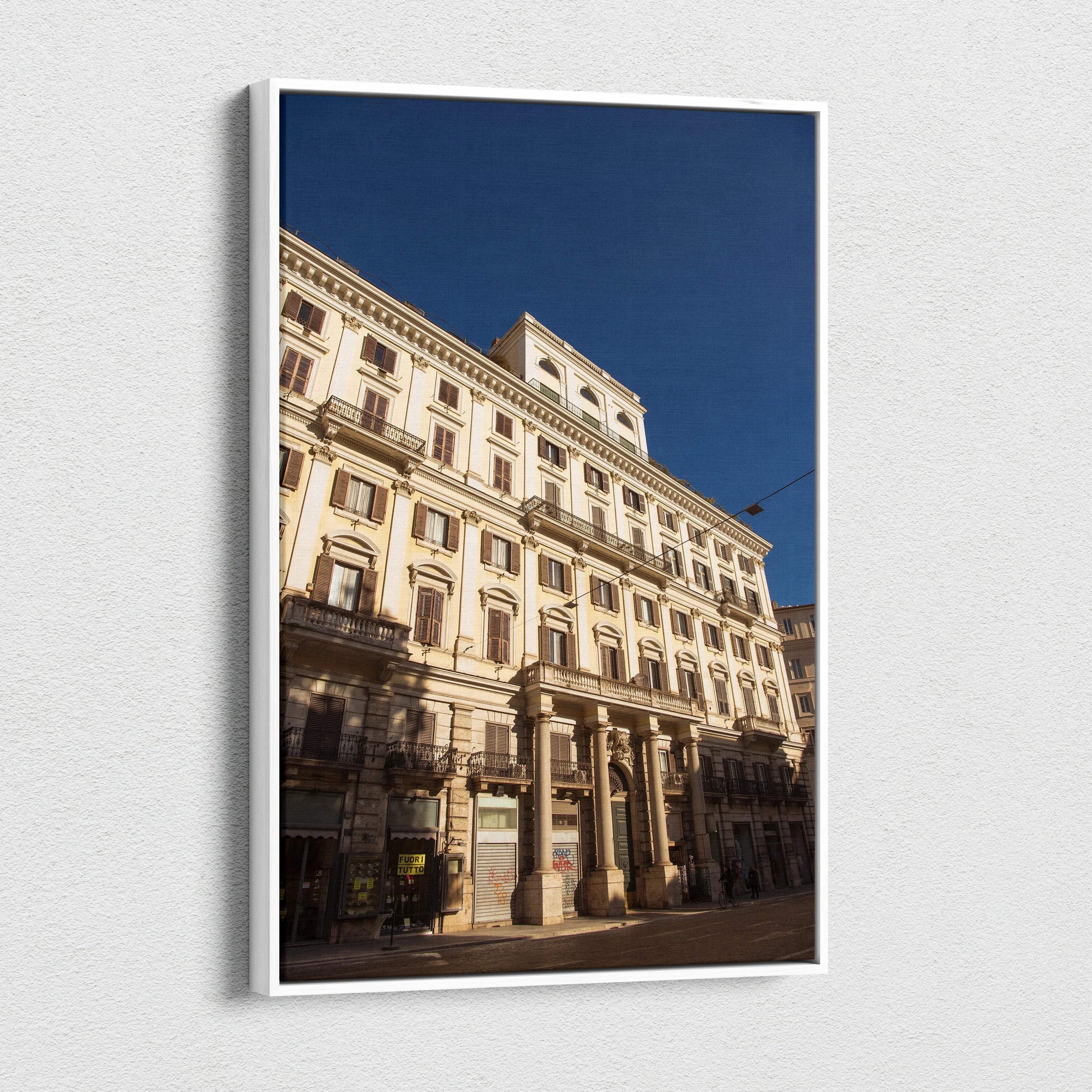 Vertical canvas wall art of detailed urban building facade against deep blue sky.
