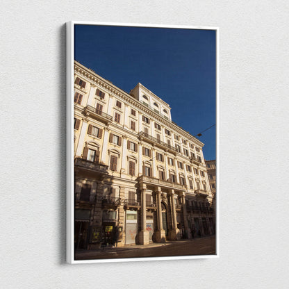 Vertical canvas wall art of detailed urban building facade against deep blue sky.