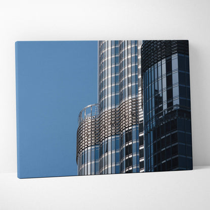 Canvas wall art featuring sleek modern skyscraper with reflective glass panels against clear blue sky.