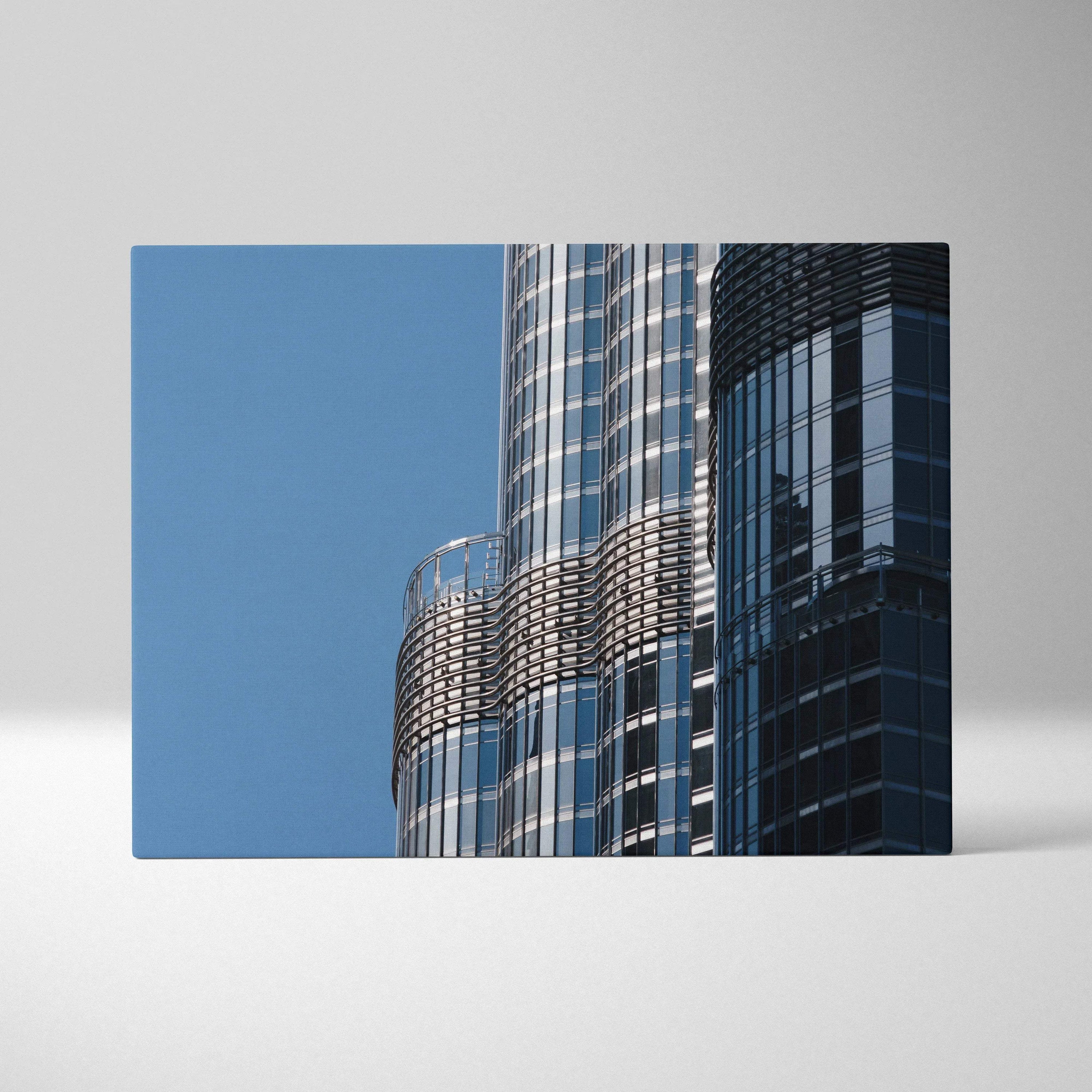 Modern architectural digital art on canvas featuring reflective glass skyscraper panels against blue sky.