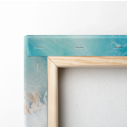 Close-up of wooden frame with teal and beige painted canvas stretched and stapled for wall art display.