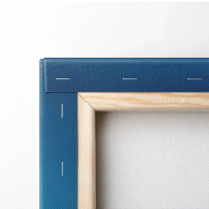 Close-up of blue canvas wall art corner with wooden frame and visible staples on back of canvas art.