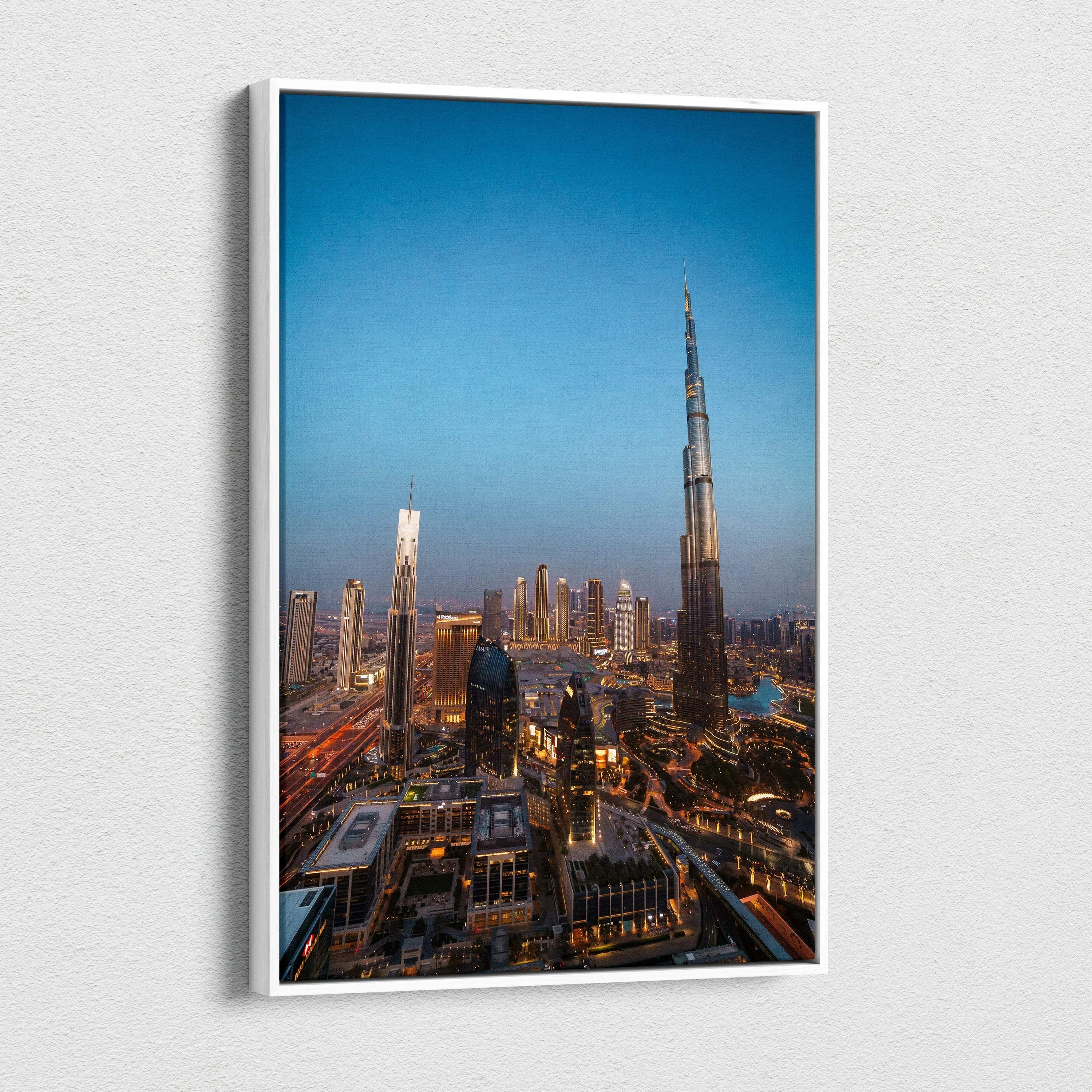 Tall modern skyscraper canvas wall art featuring cityscape at dusk with warm lighting and blue sky backdrop.