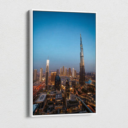 Tall modern skyscraper canvas wall art featuring cityscape at dusk with warm lighting and blue sky backdrop.