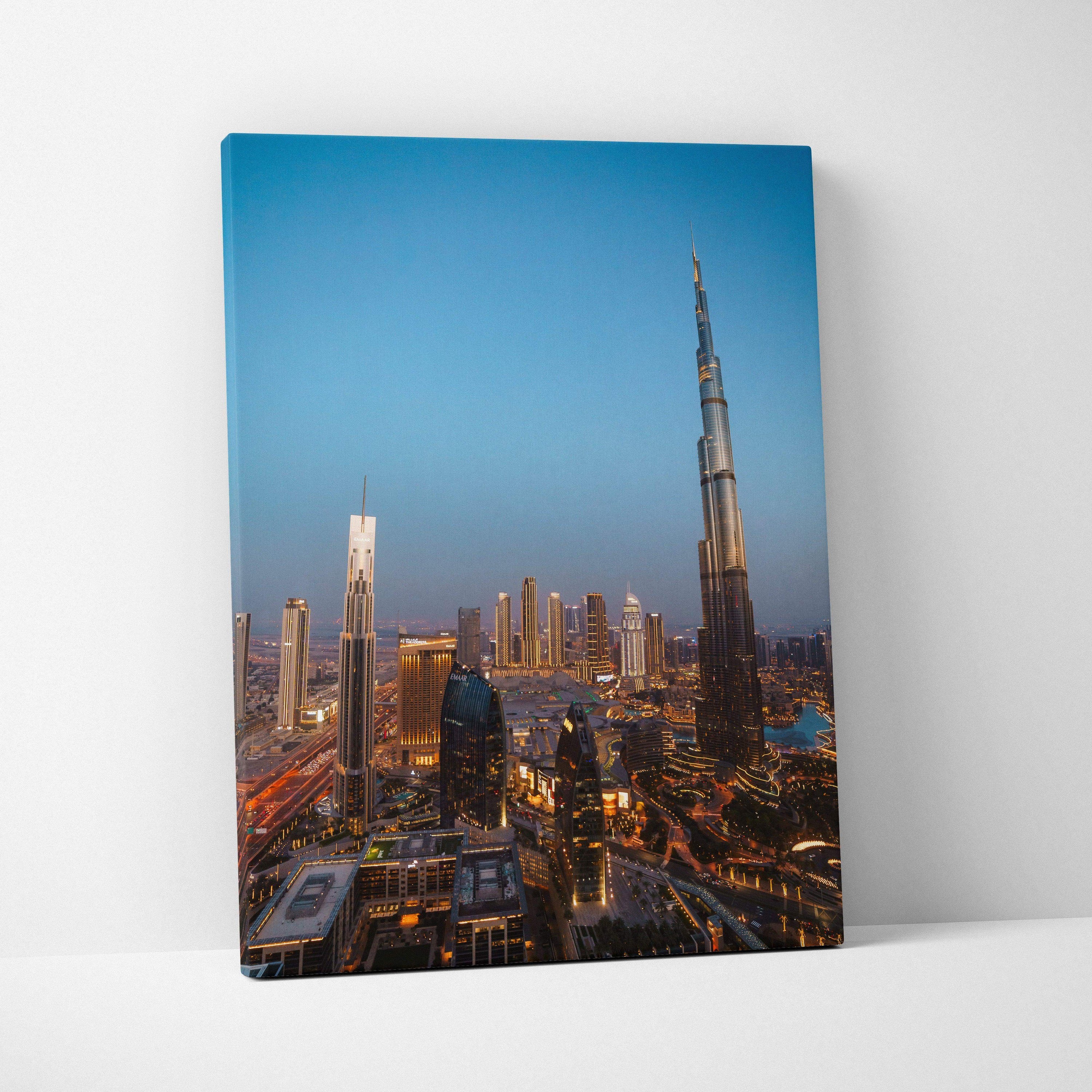 Vertical canvas wall art of illuminated city skyline featuring Burj Khalifa at dusk.