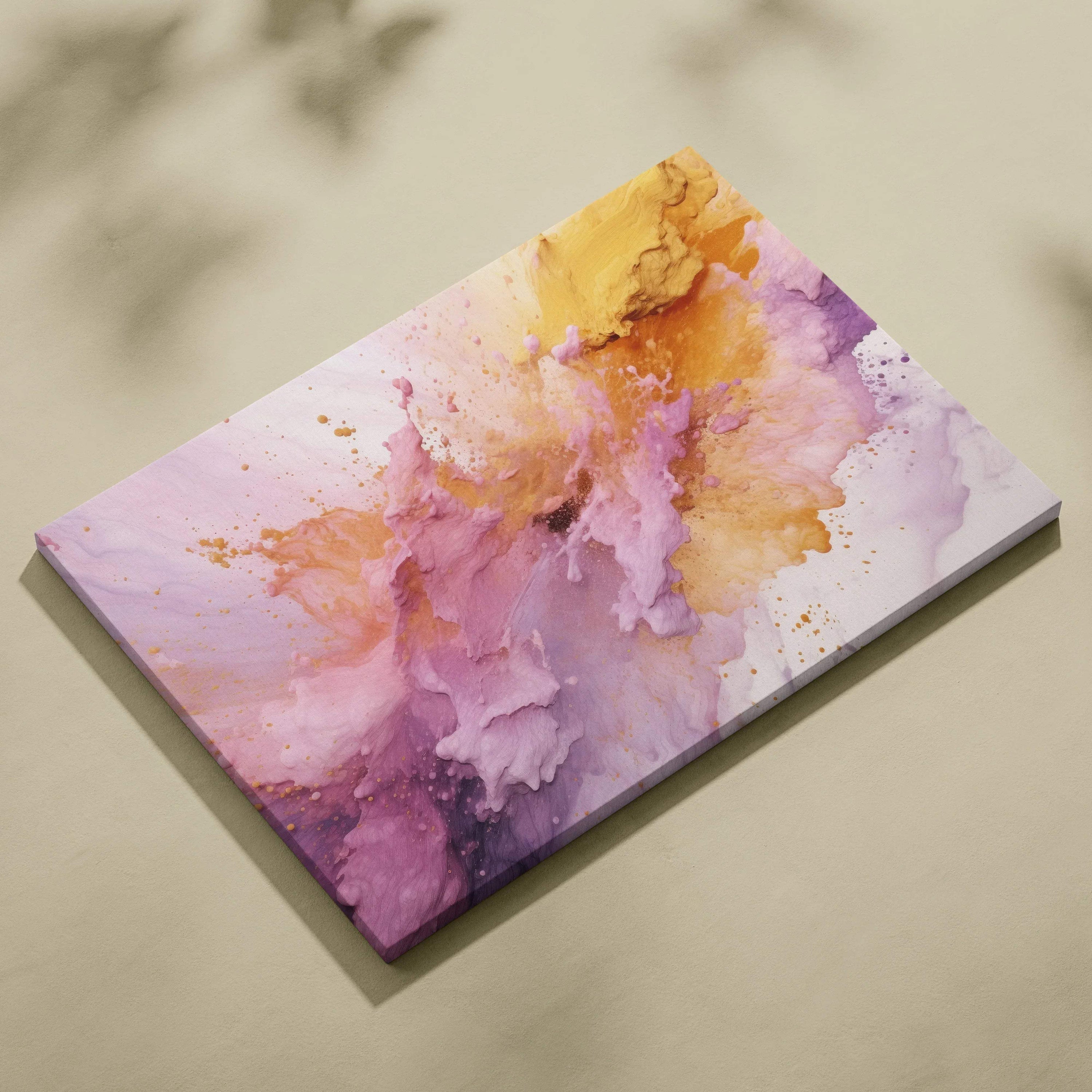Abstract canvas wall art with vibrant splashes of purple, pink, and yellow tones on a smooth surface.