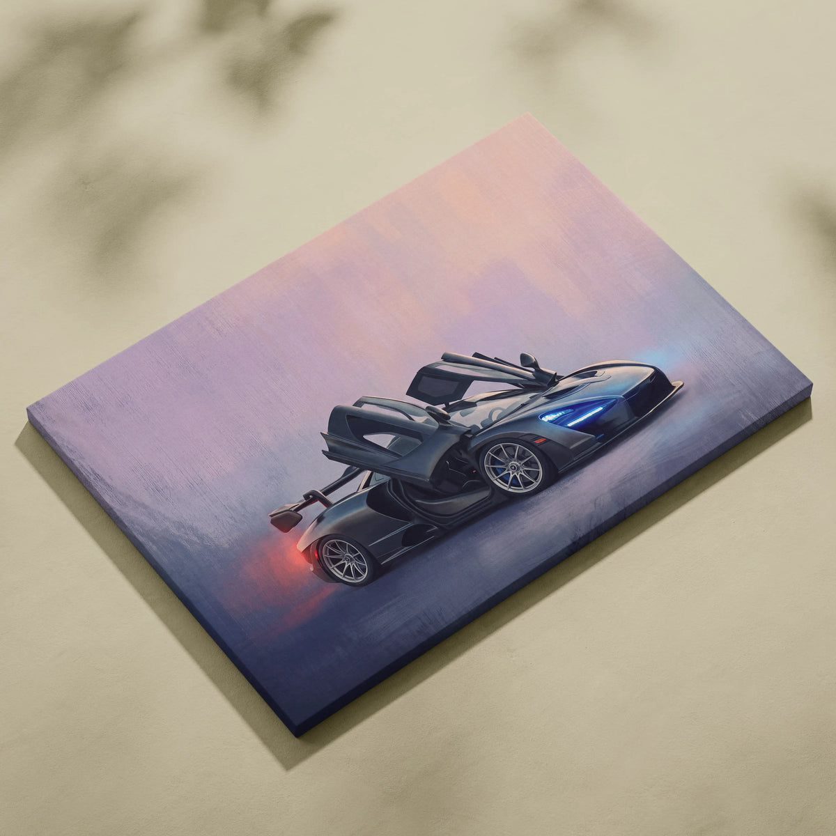 A sleek black McLaren supercar with glowing blue headlights on premium canvas art for automotive wall decor
