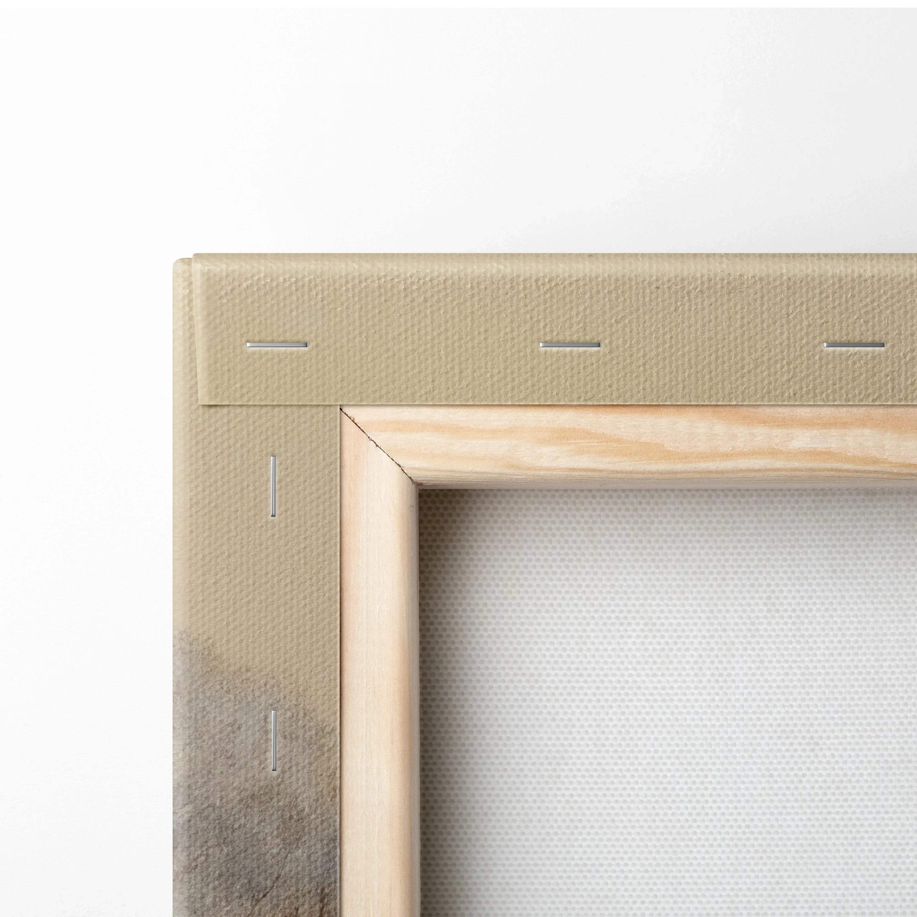 Close-up of beige stretched canvas fabric wrapped around light wood frame with visible metal staples for wall art decor.