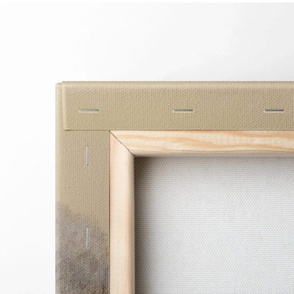 Close-up of beige stretched canvas fabric wrapped around light wood frame with visible metal staples for wall art decor.