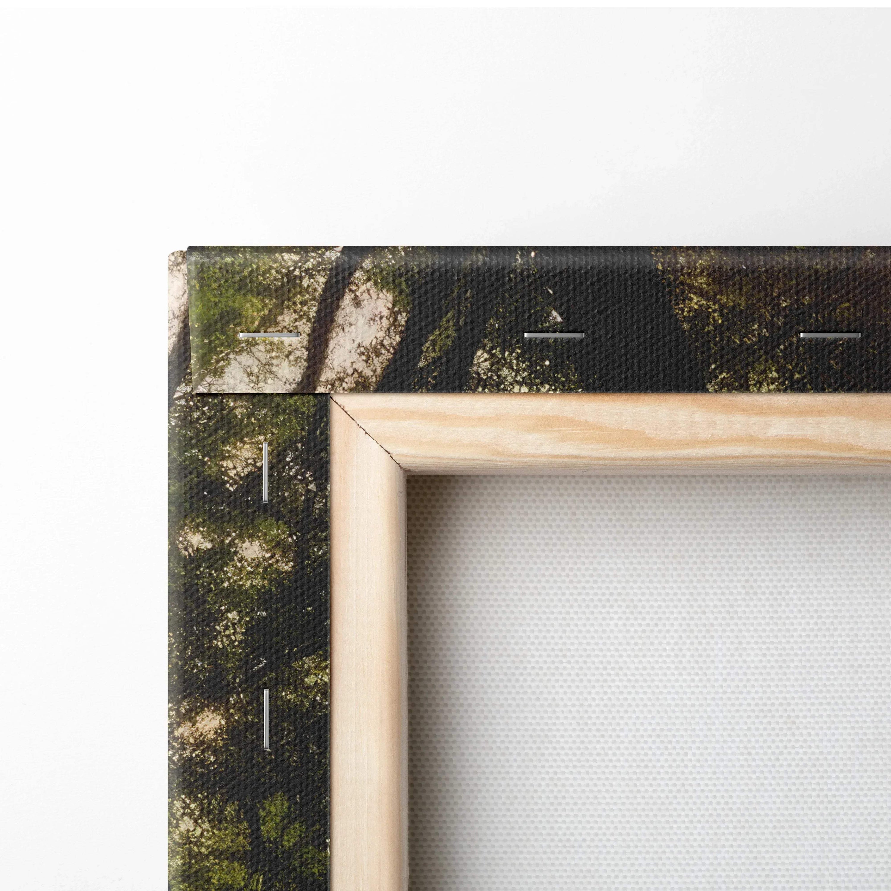 Close-up of stretched canvas wall art corner showing wooden frame and forest sunset print for home decor.