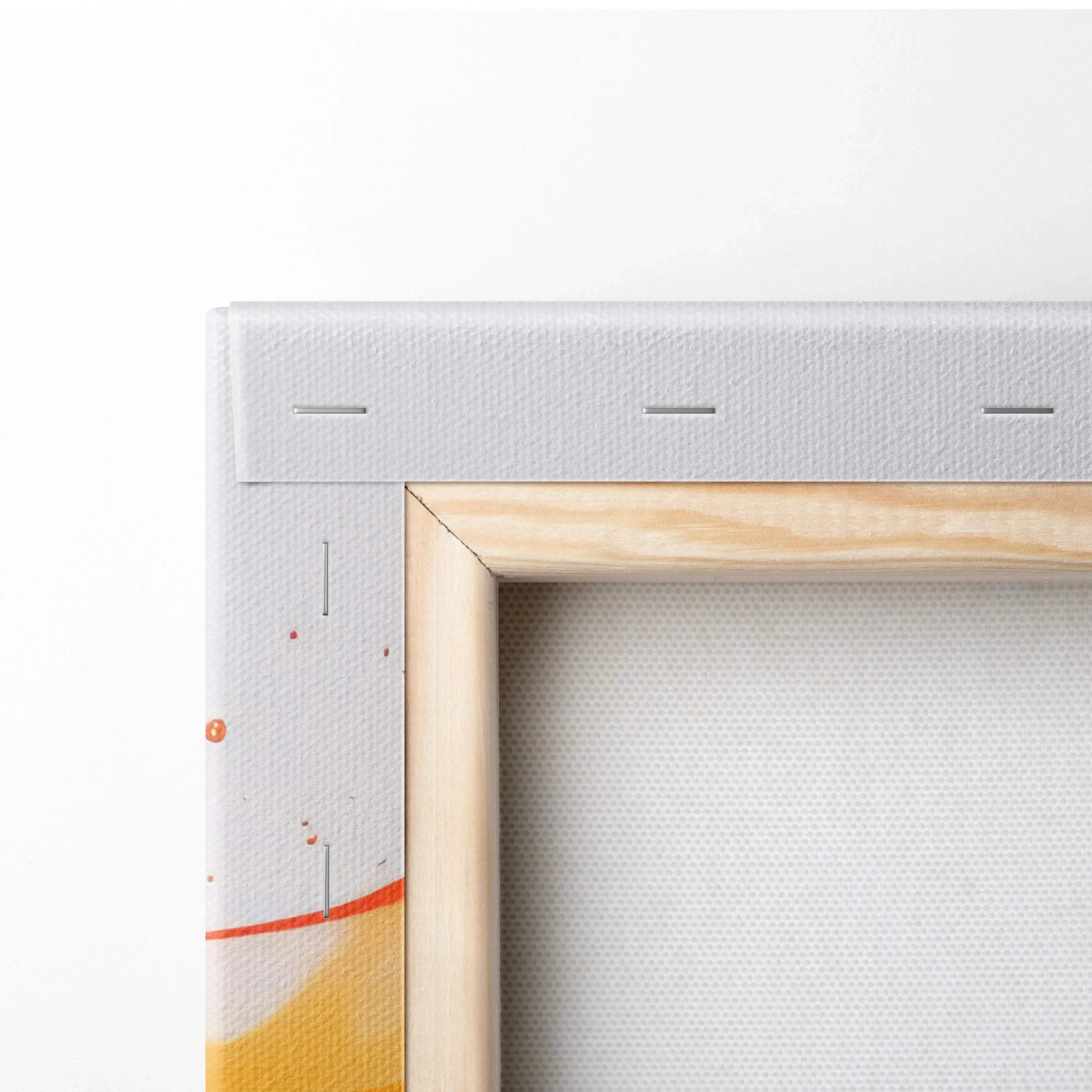 Close-up of stretched canvas corner with visible staples, natural wood frame, and abstract orange and red paint splashes on.