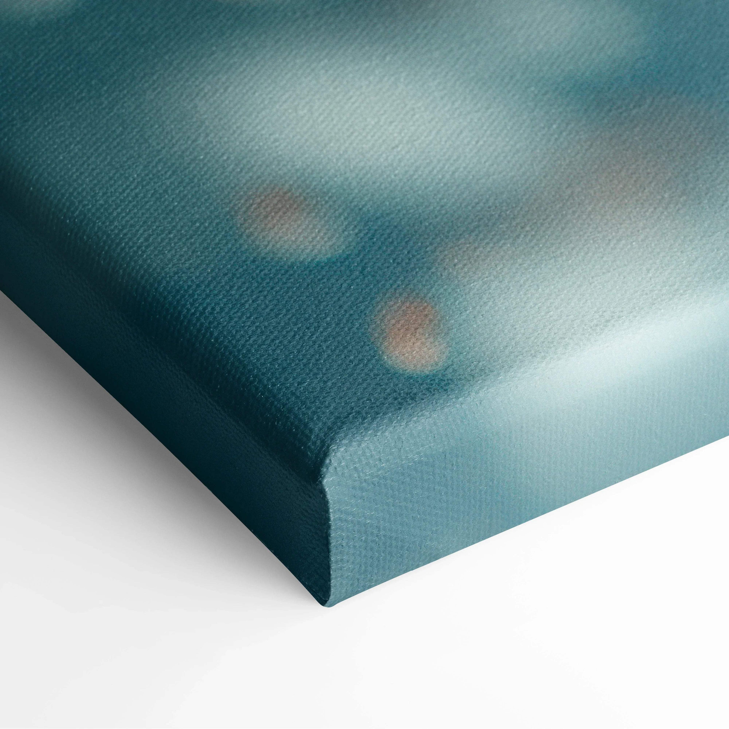 Close-up of textured canvas wall art with soft blue hues and hints of orange shapes.