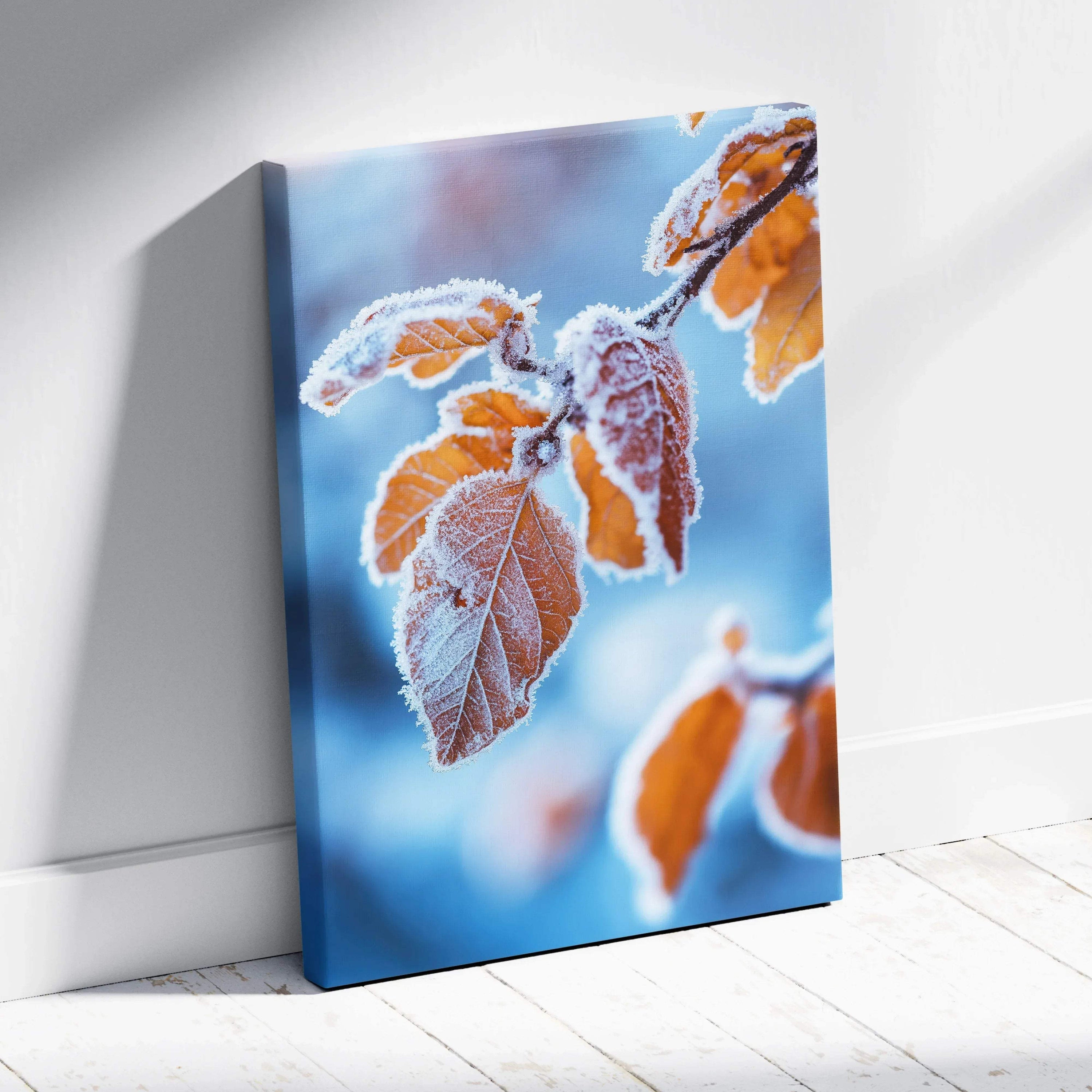 Vertical canvas wall art featuring vibrant autumn leaves with frost against a soft blue sky background.