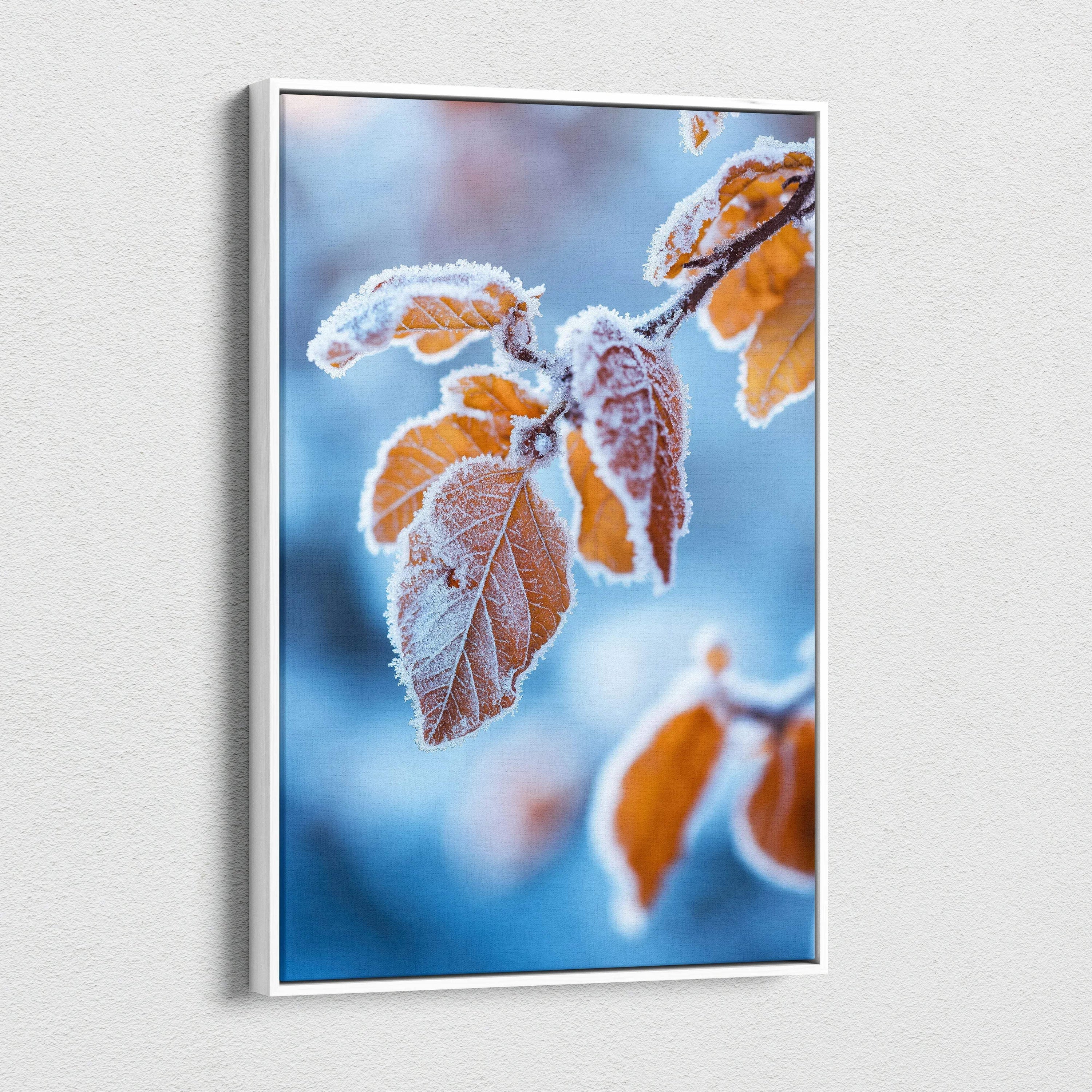 Vertical canvas wall art featuring vibrant autumn leaves with frosted edges against a soft blue background.
