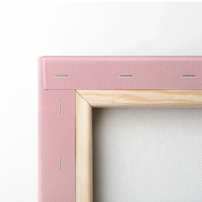 Close-up of pink stretched canvas with natural wood frame corner and staples, canvas art wall decor.
