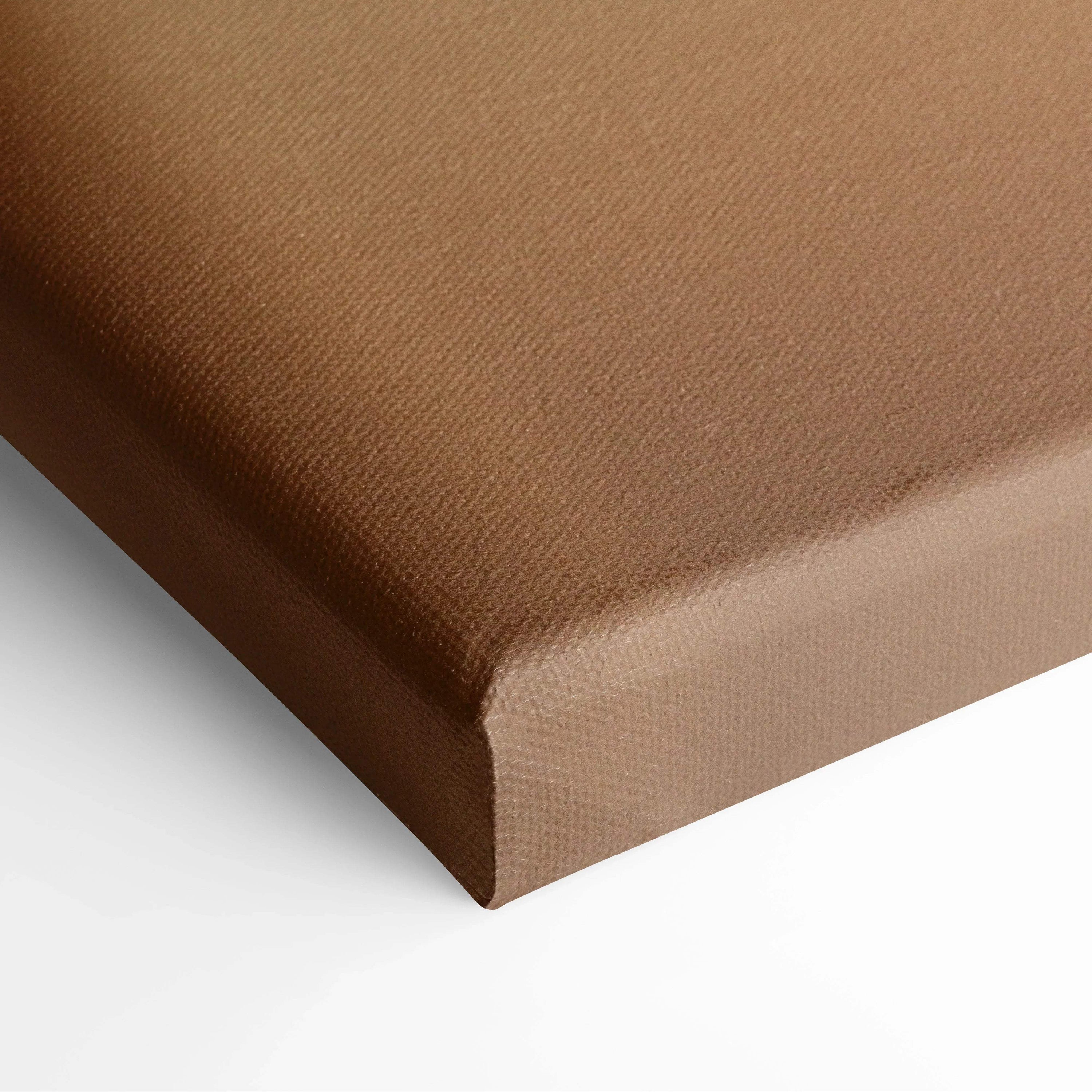 Close-up of textured brown canvas wall art with wrapped edges for home decor.