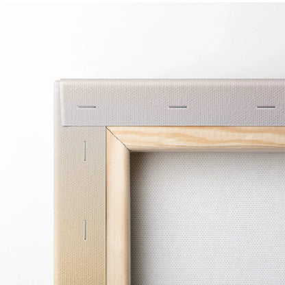 Close-up of beige canvas stretched on light wood frame with visible staples and texture.