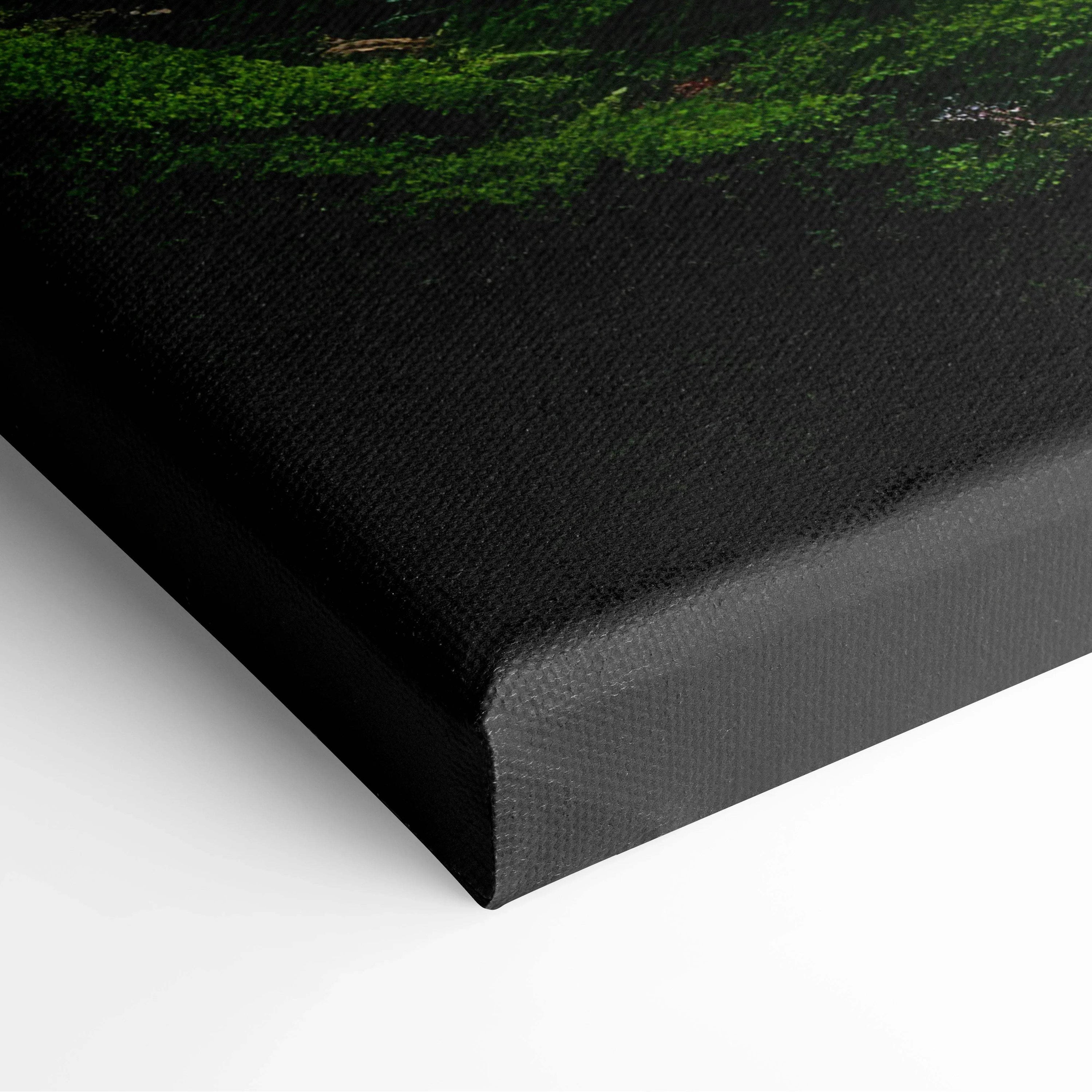 Close-up of canvas wall art corner showing moss-covered rocks and layered trees in serene forest decor.