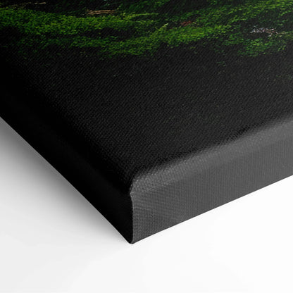 Close-up of canvas wall art corner showing moss-covered rocks and layered trees in serene forest decor.