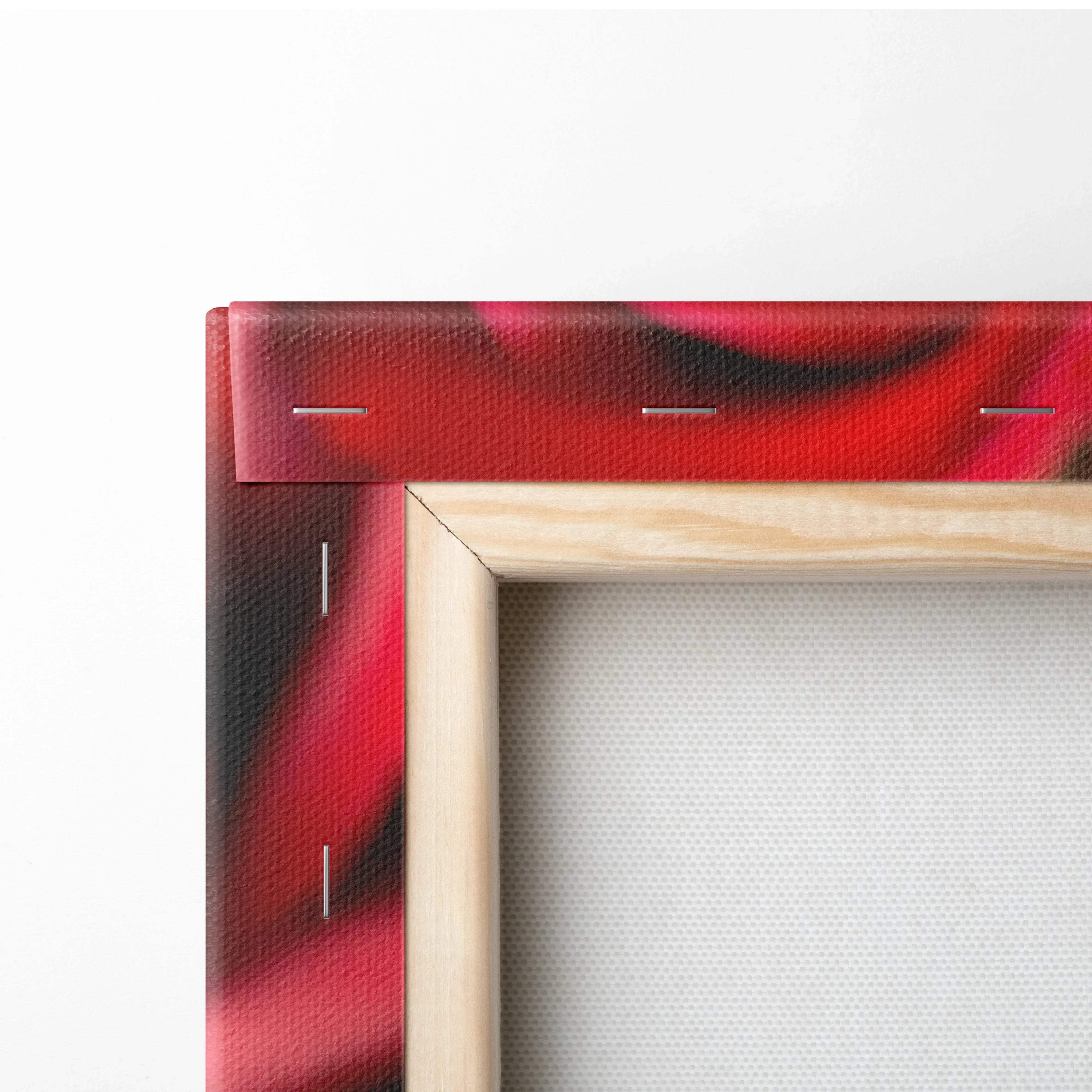 Close-up of corner of stretched canvas wall art showing vibrant red and black floral print with wooden frame and visible.