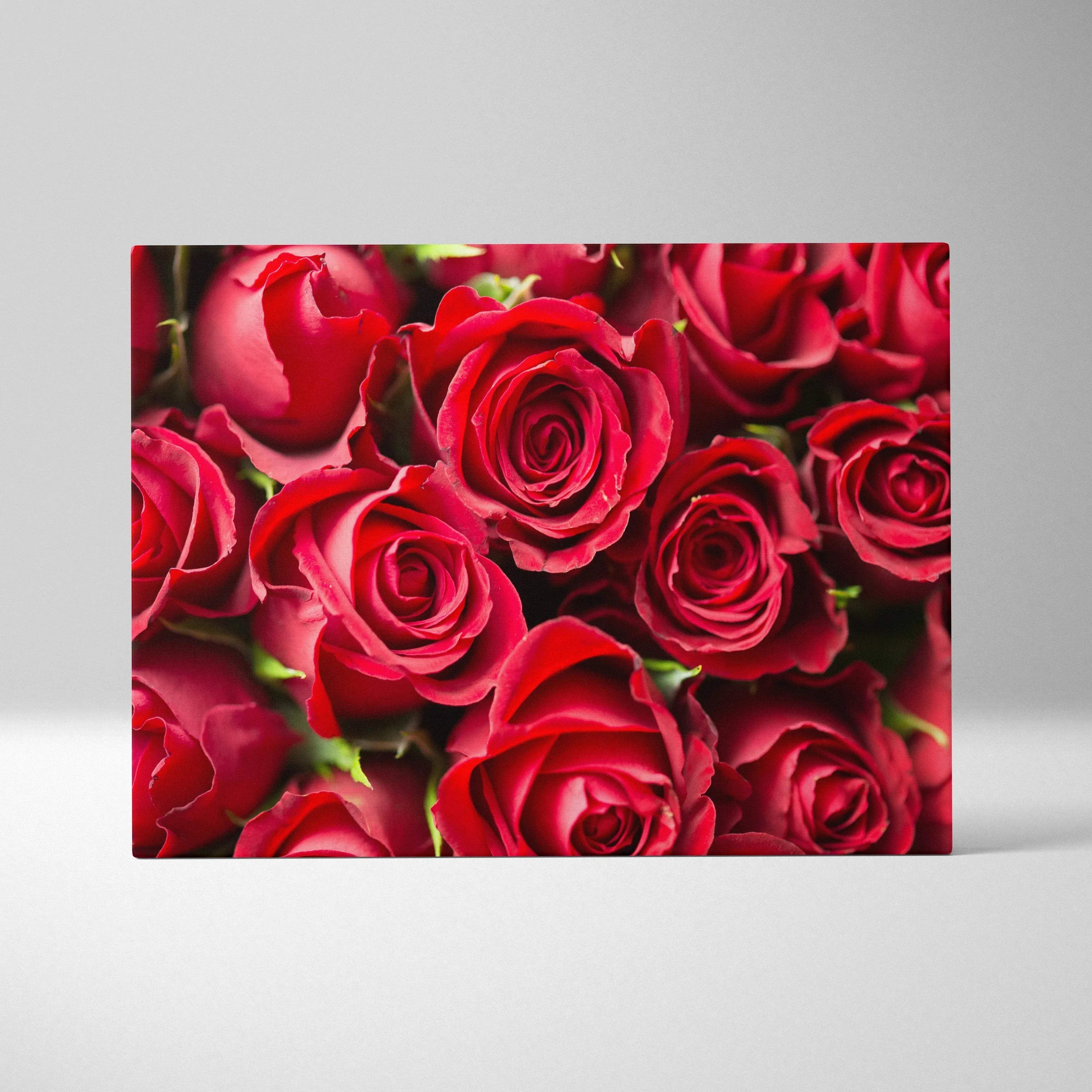 Canvas wall art featuring a close-up of vibrant red roses with detailed petals and rich green accents.