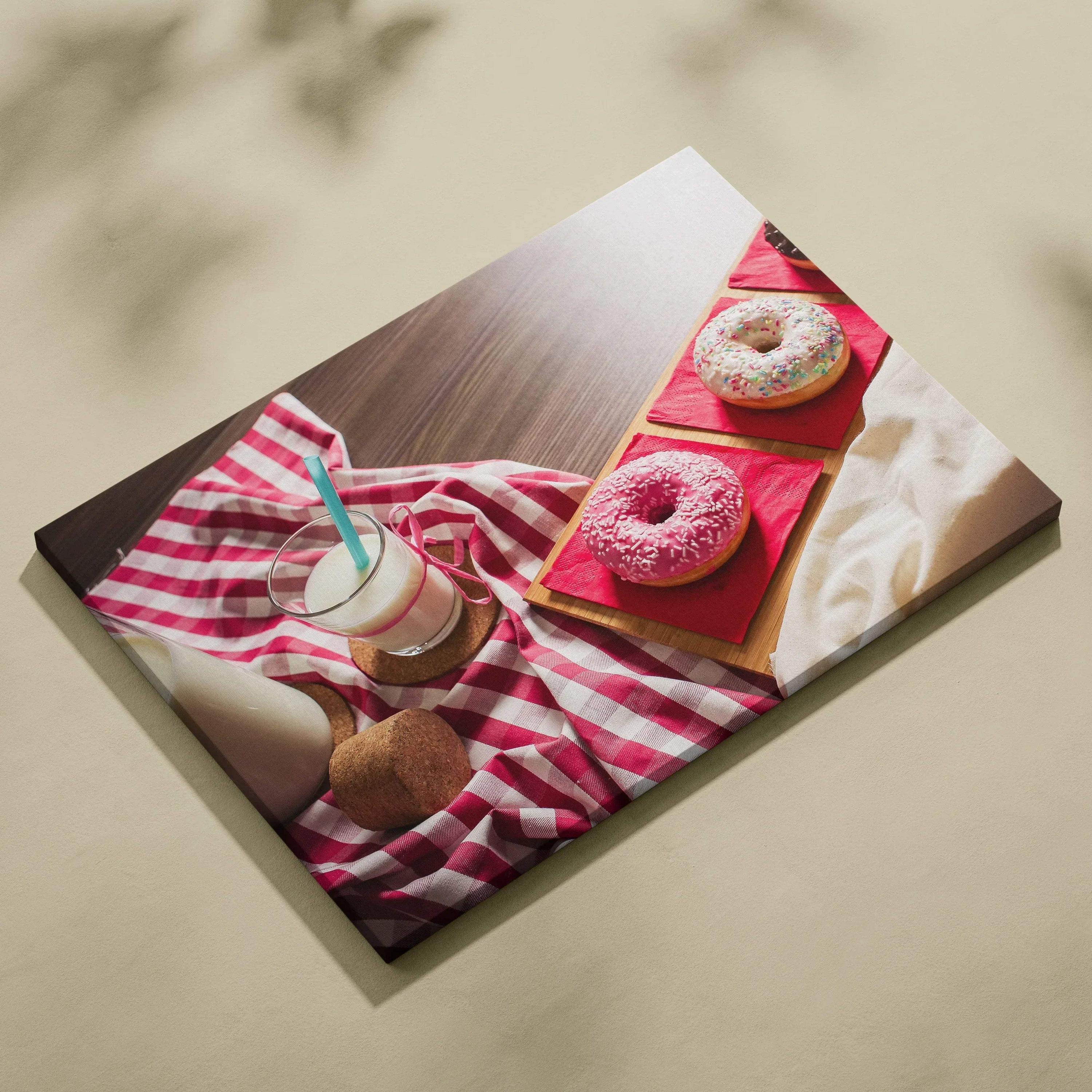 High-resolution canvas wall art featuring colorful sprinkled donuts and a glass of milk on a red-striped cloth, vibrant food