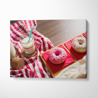 Canvas wall art featuring vibrant pink and white frosted donuts with sprinkles on a wooden table with a red and white.