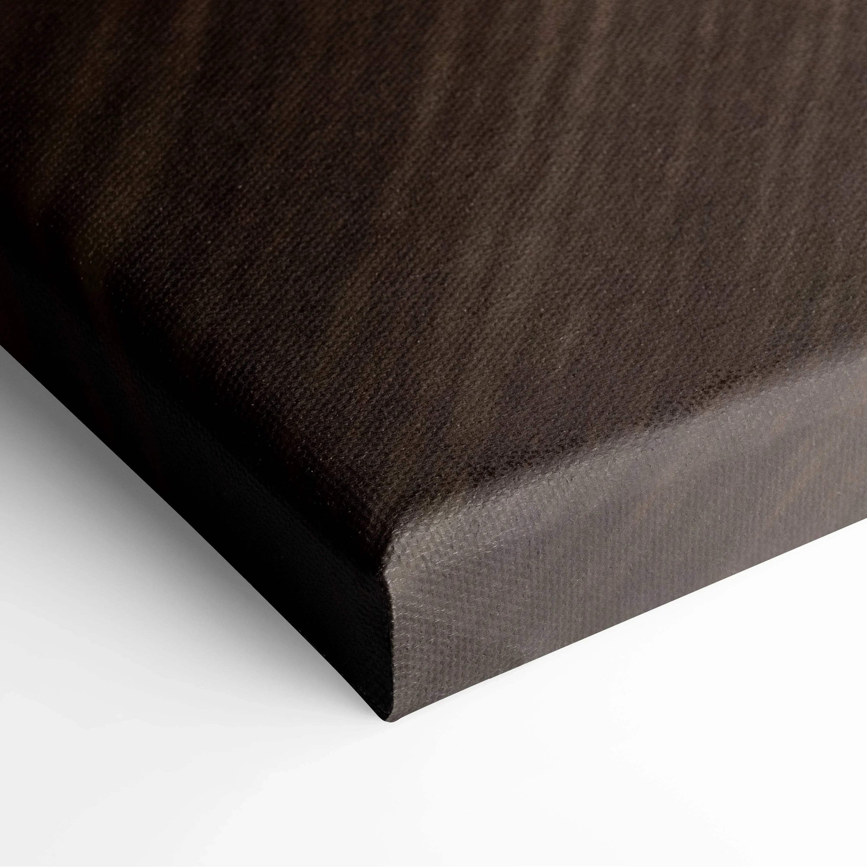 Close-up of wrapped canvas corner with textured black fabric and tight, smooth edges.