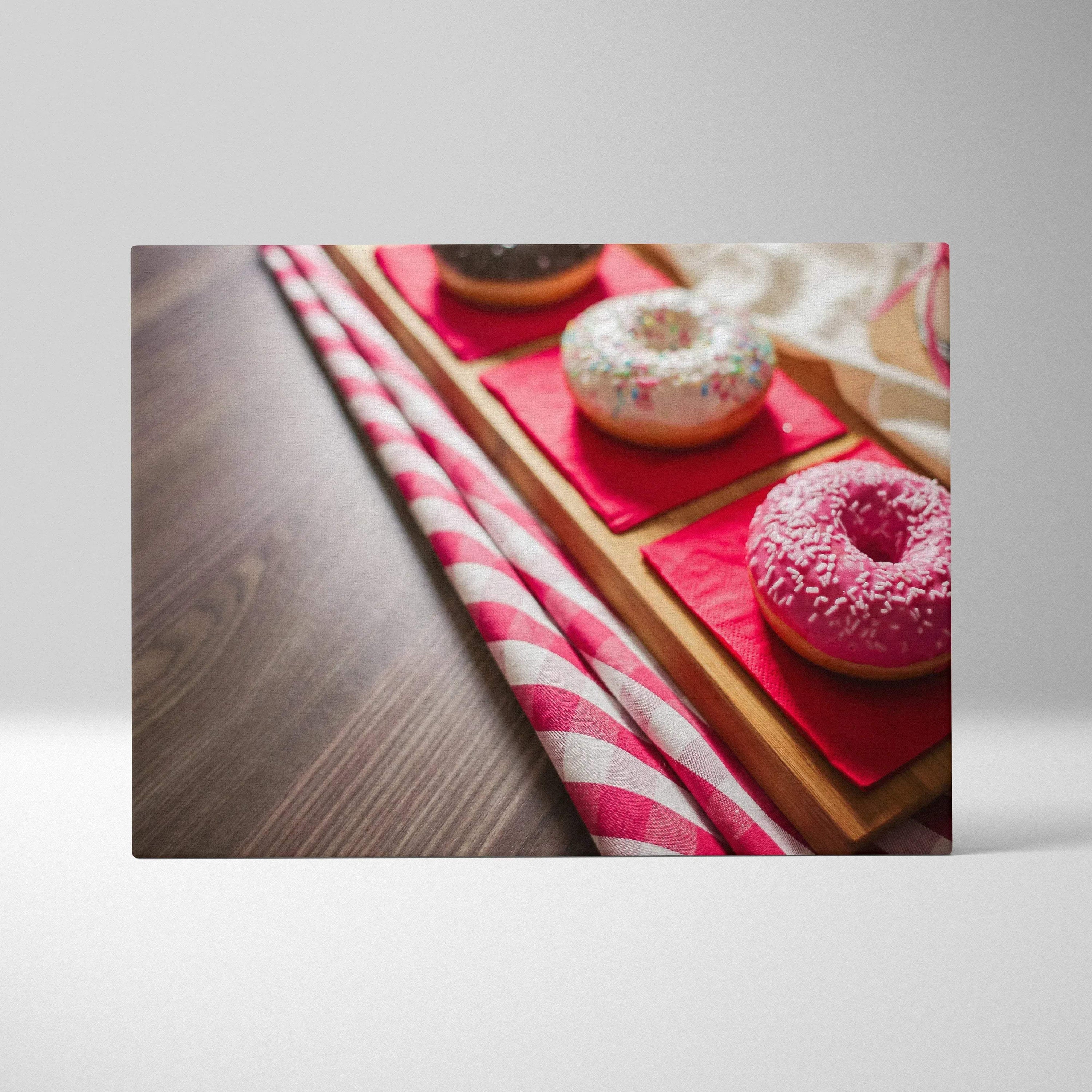 Canvas wall art featuring vibrant glazed donuts in pink, white, and chocolate with colorful sprinkles on wooden trays.