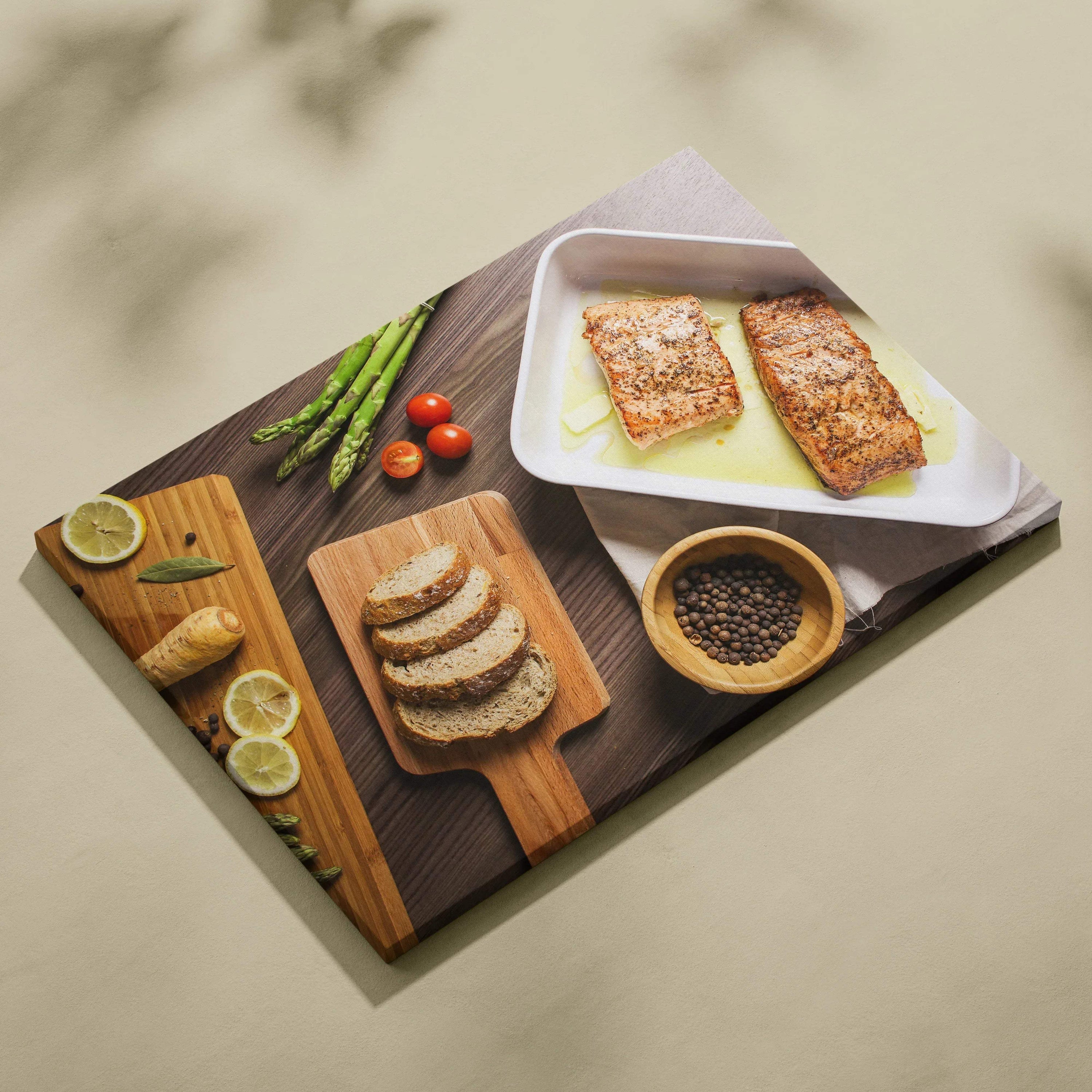 Canvas wall art depicting a lunch table scene with bread, salmon on plates, asparagus, cherry tomatoes, and lemon slices on.