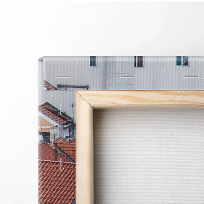 Close-up of wooden frame and textured canvas featuring detailed architectural digital art with red rooftops and light gray.