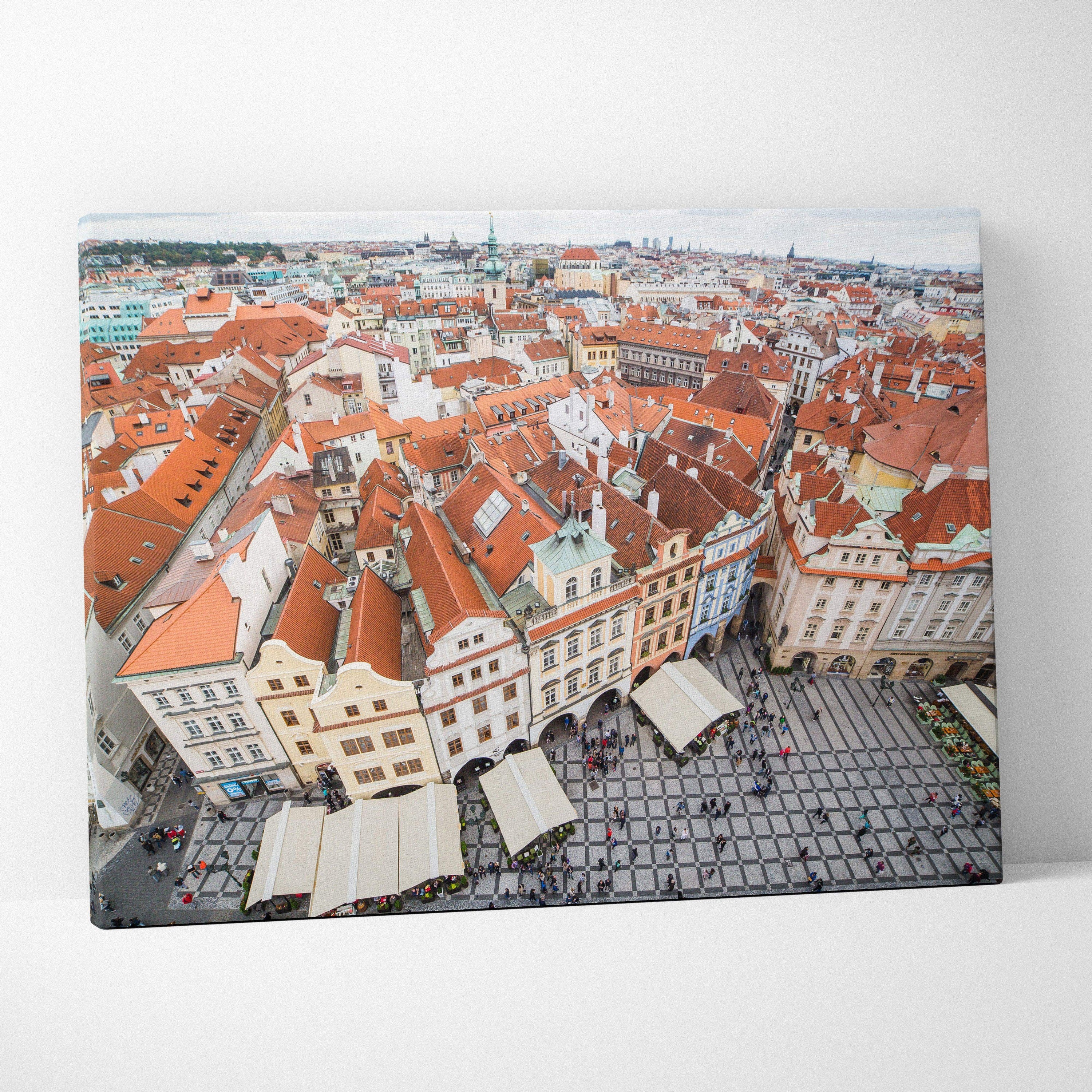 Cityscape canvas art featuring detailed red-roofed buildings and a bustling square in warm tones.