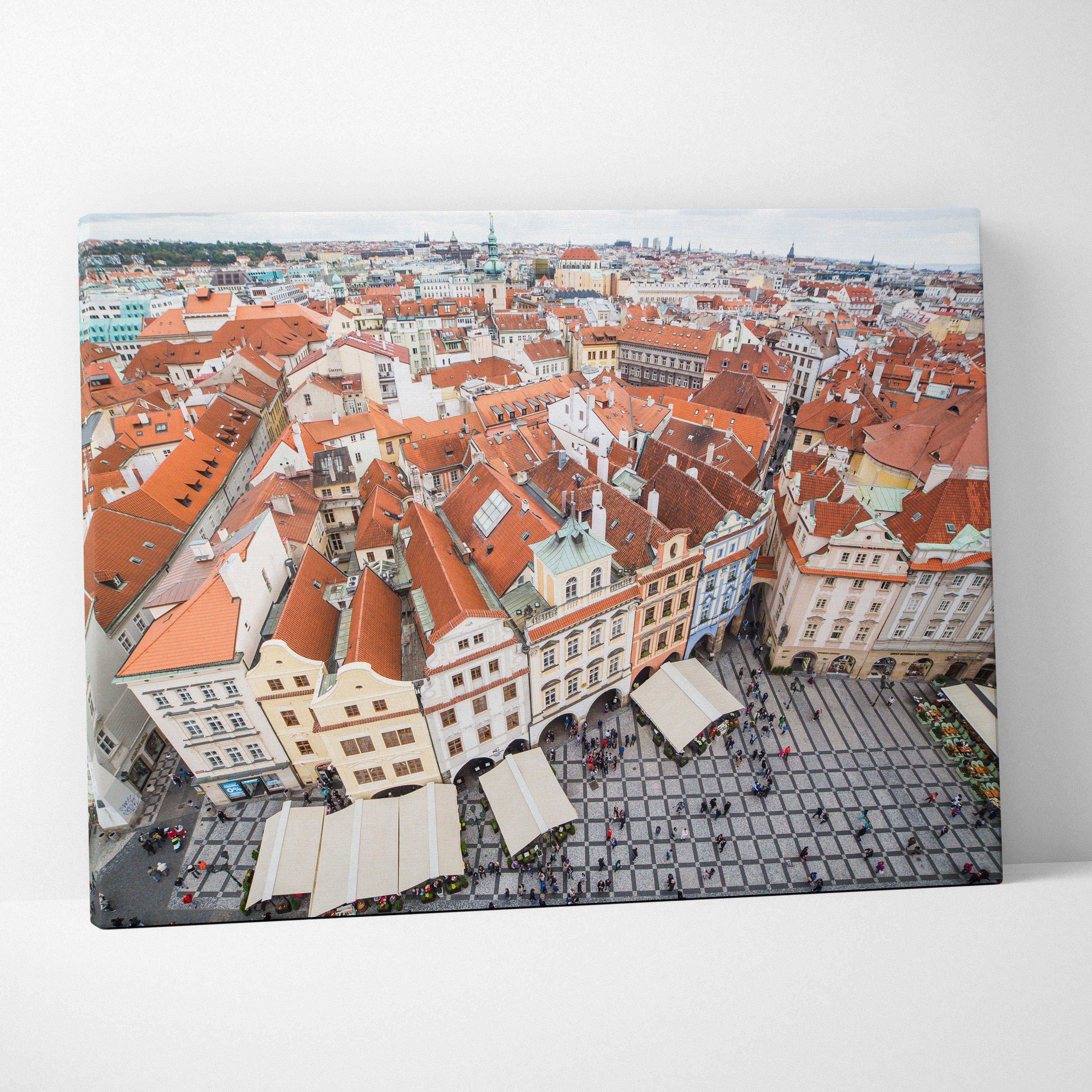 A canvas print featuring an aerial view of historic european city rooftops with red tiles and cobblestone streets