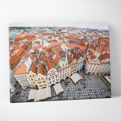 Cityscape canvas art featuring detailed red-roofed buildings and a bustling square in warm tones.