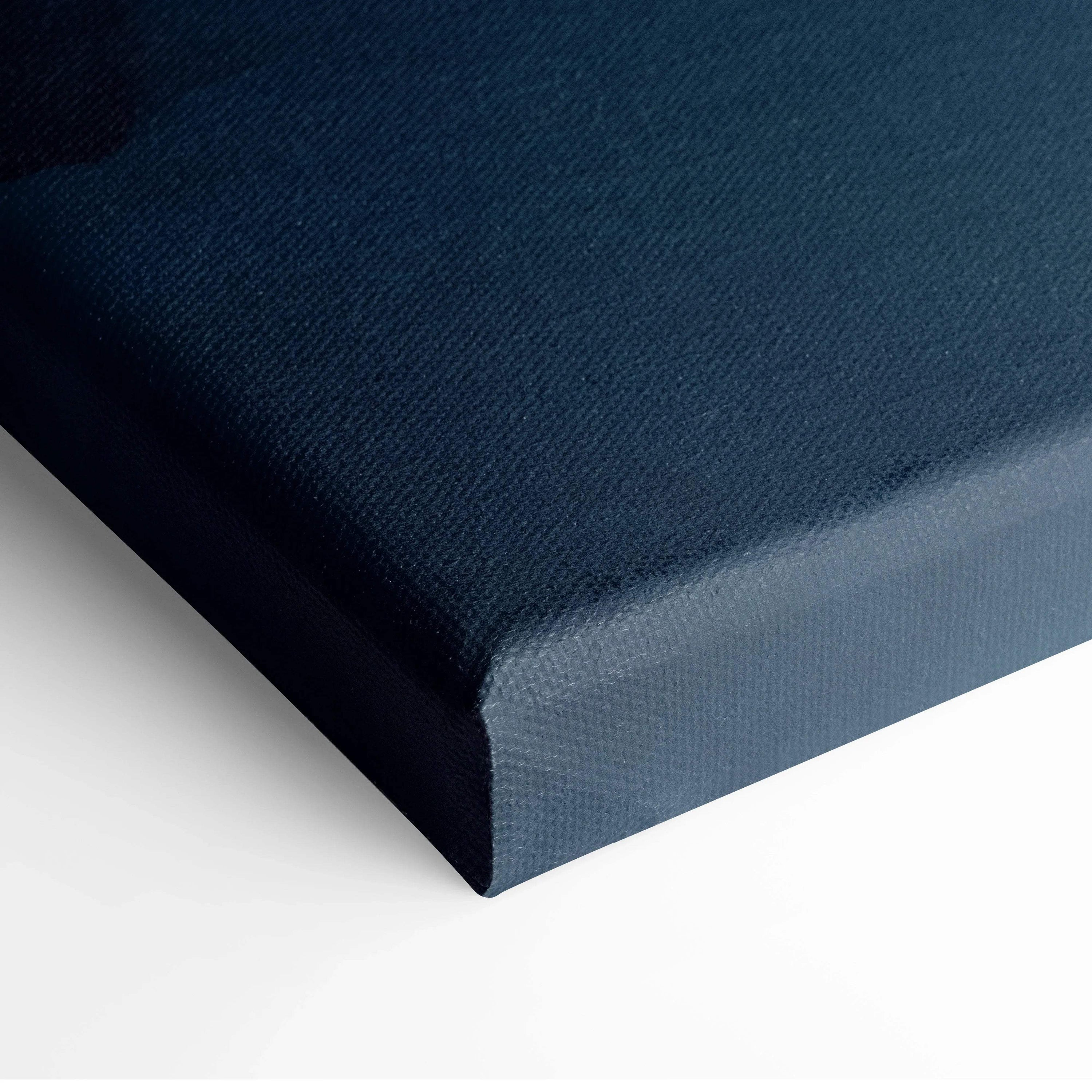 Close-up of navy blue canvas fabric stretched over wooden frame for wall art decor.