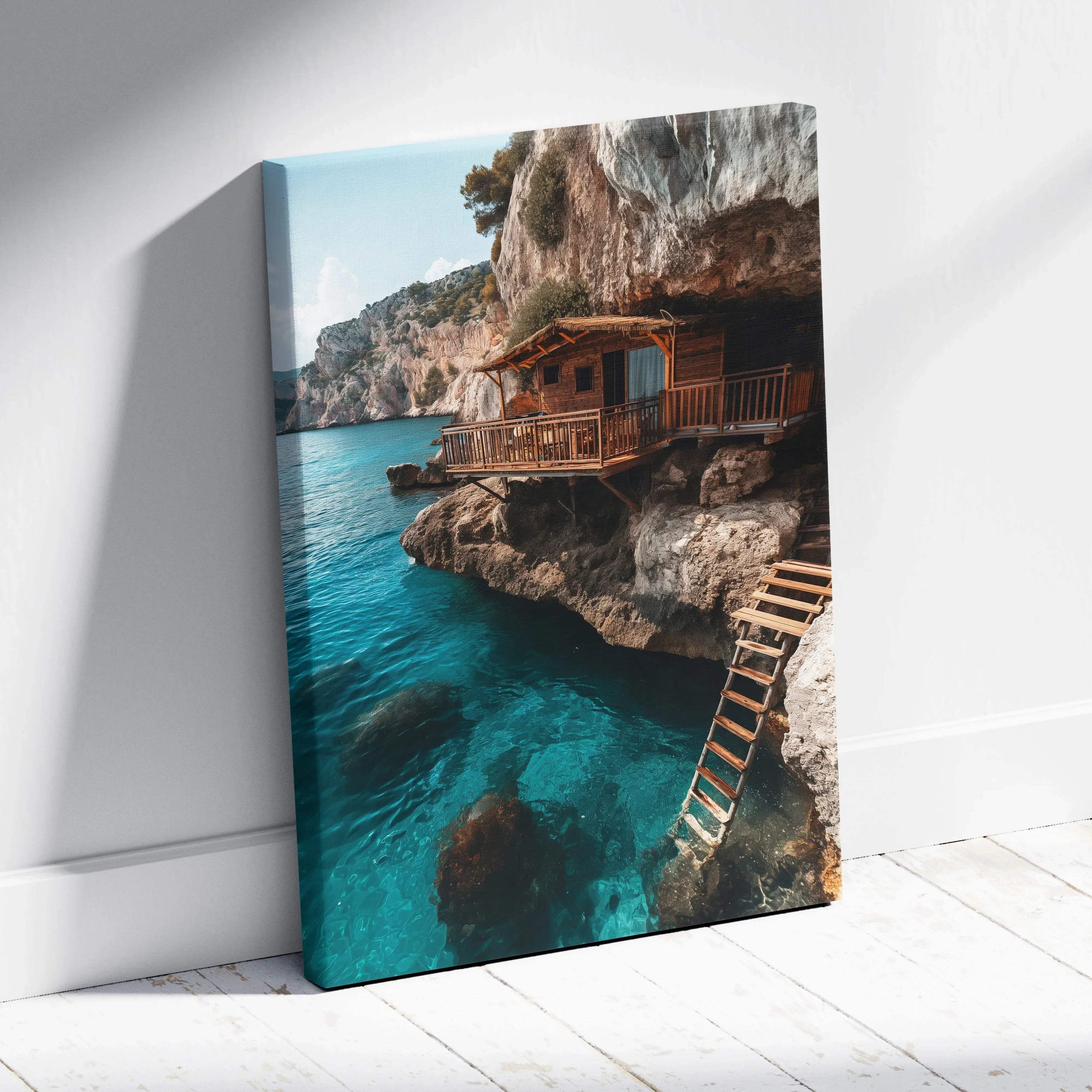 Canvas wall art featuring coastal architecture with a wooden cabin perched on rocky cliffs over clear blue water.