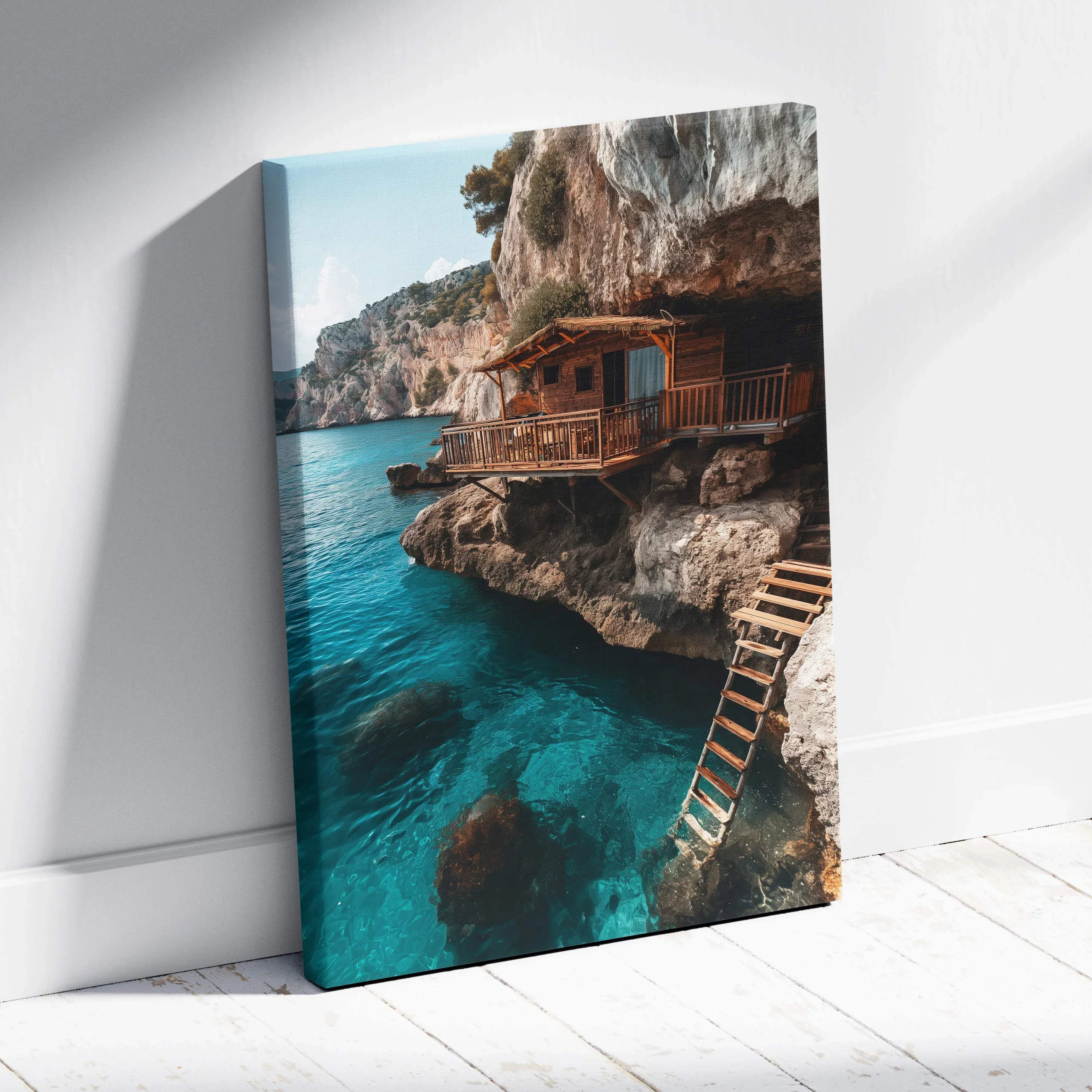 A vibrant canvas wall art showing a rustic wooden cabin on rocky cliffs over turquoise sea with a weathered ladder