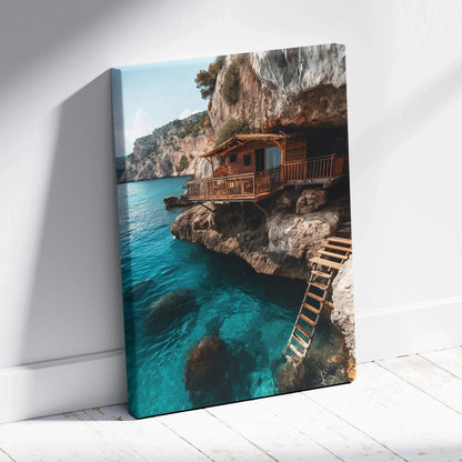 Canvas wall art featuring coastal architecture with a wooden cabin perched on rocky cliffs over clear blue water.