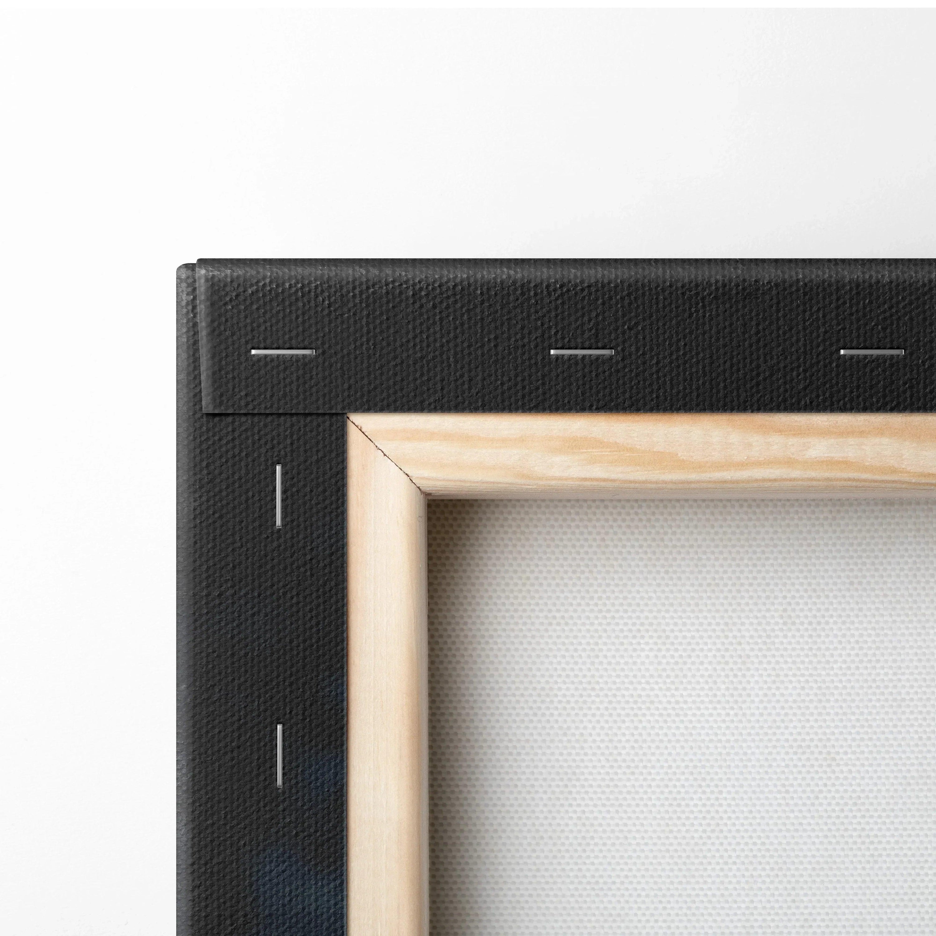 Close-up of a stretched white canvas on a light wood frame with black fabric backing stapled at the corner.