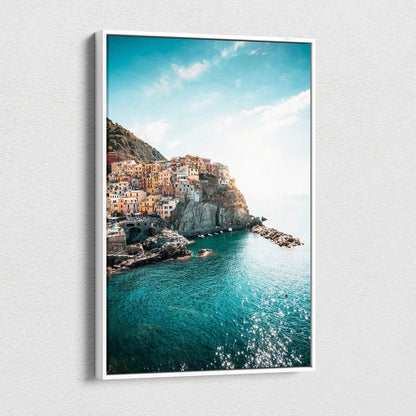 Canvas wall art featuring colorful Italian coastal buildings on rocky cliffs with vibrant turquoise sea under a bright blue.