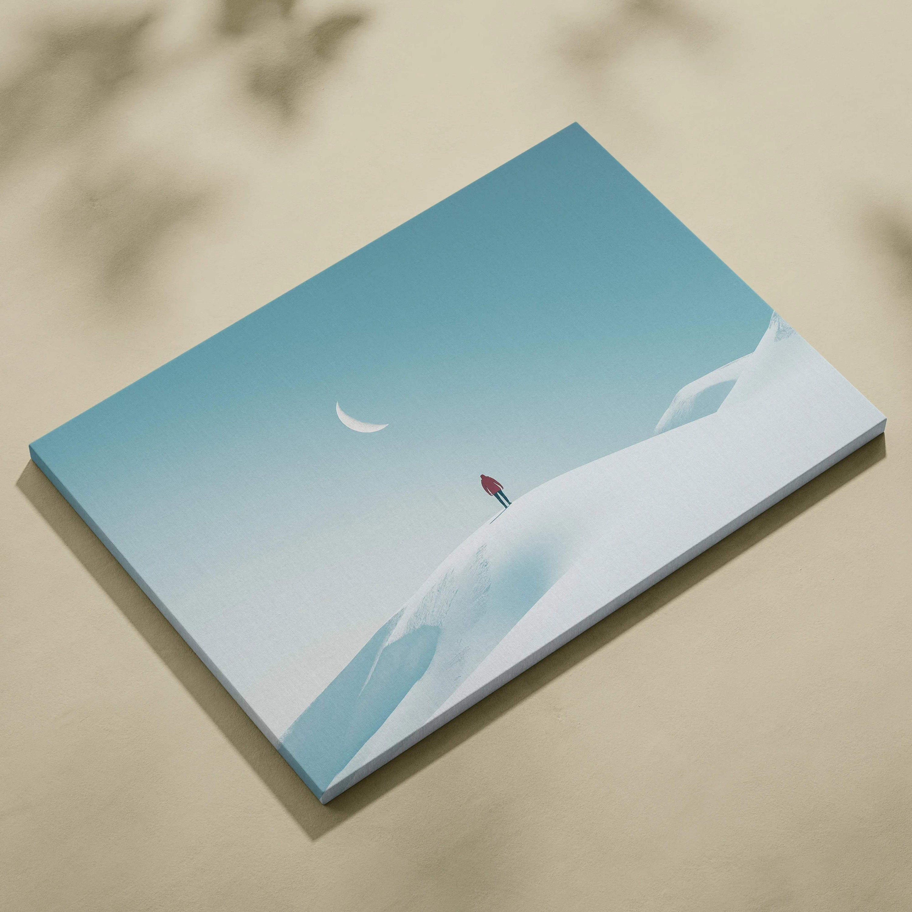 Canvas wall art featuring a man standing on a snowy hill under a glowing crescent moon in a clear blue sky.