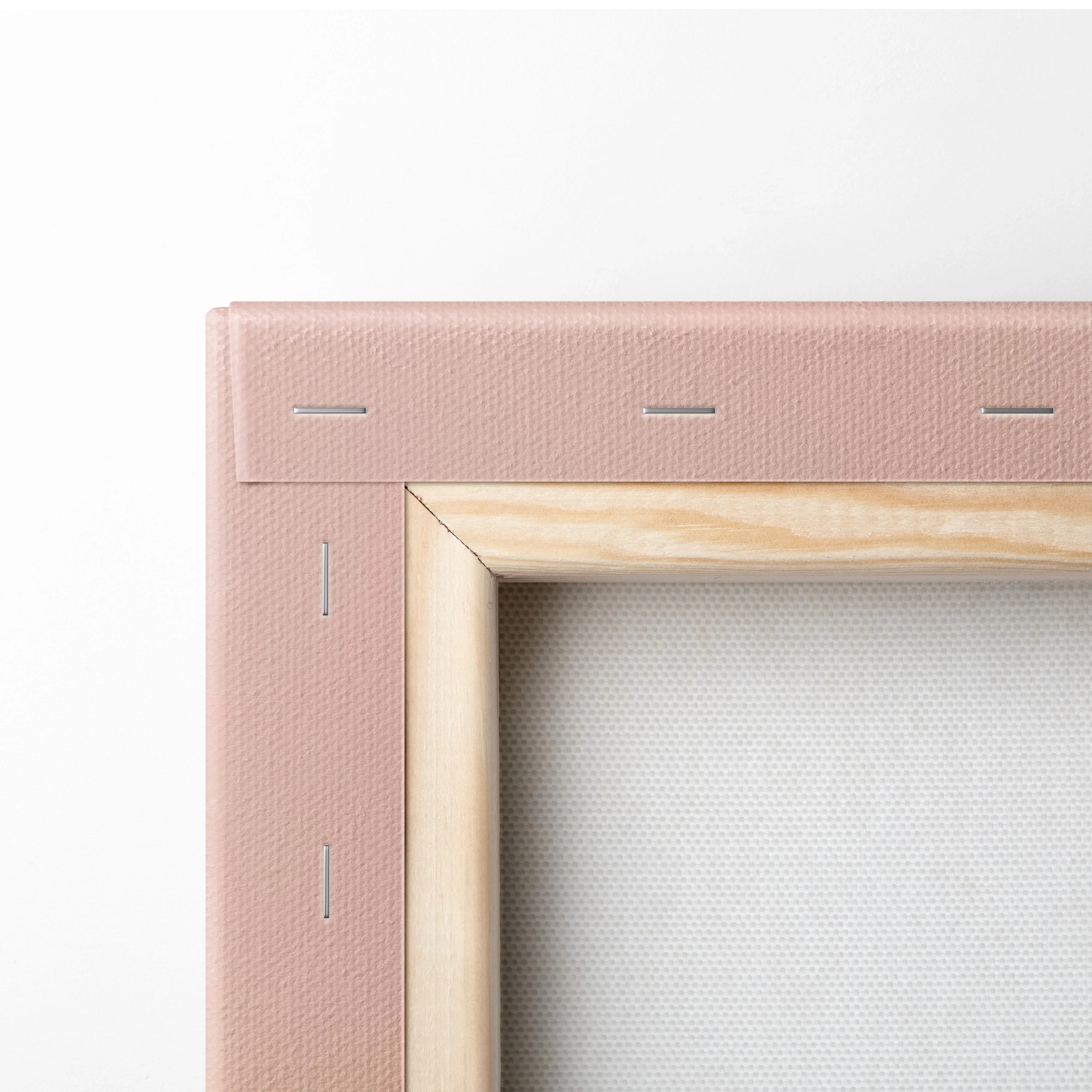 Close-up of canvas edge with pink fabric wrap and wooden frame detailing.