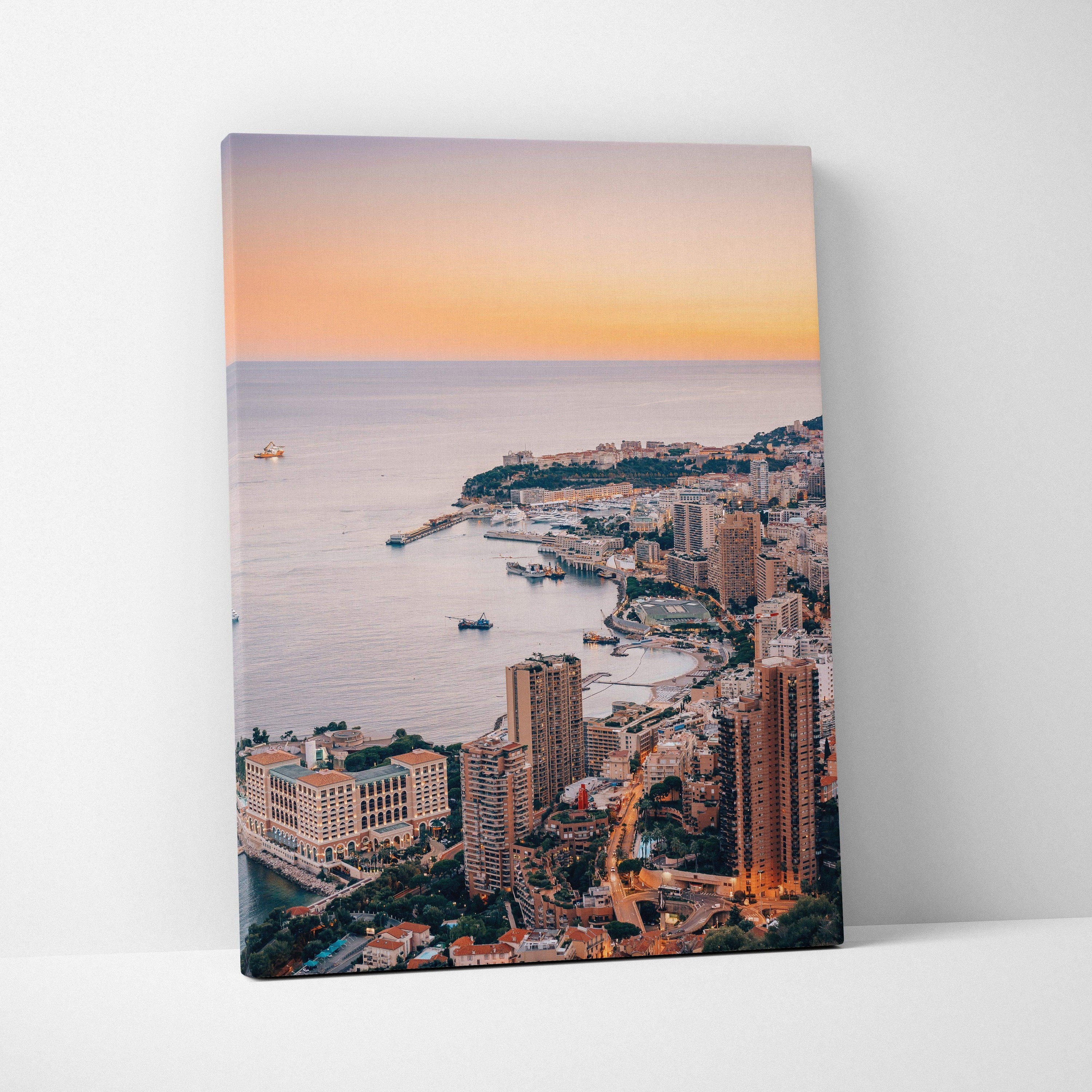 Canvas wall art featuring a digital aerial view of Monaco architecture with warm sunset tones and coastal buildings.