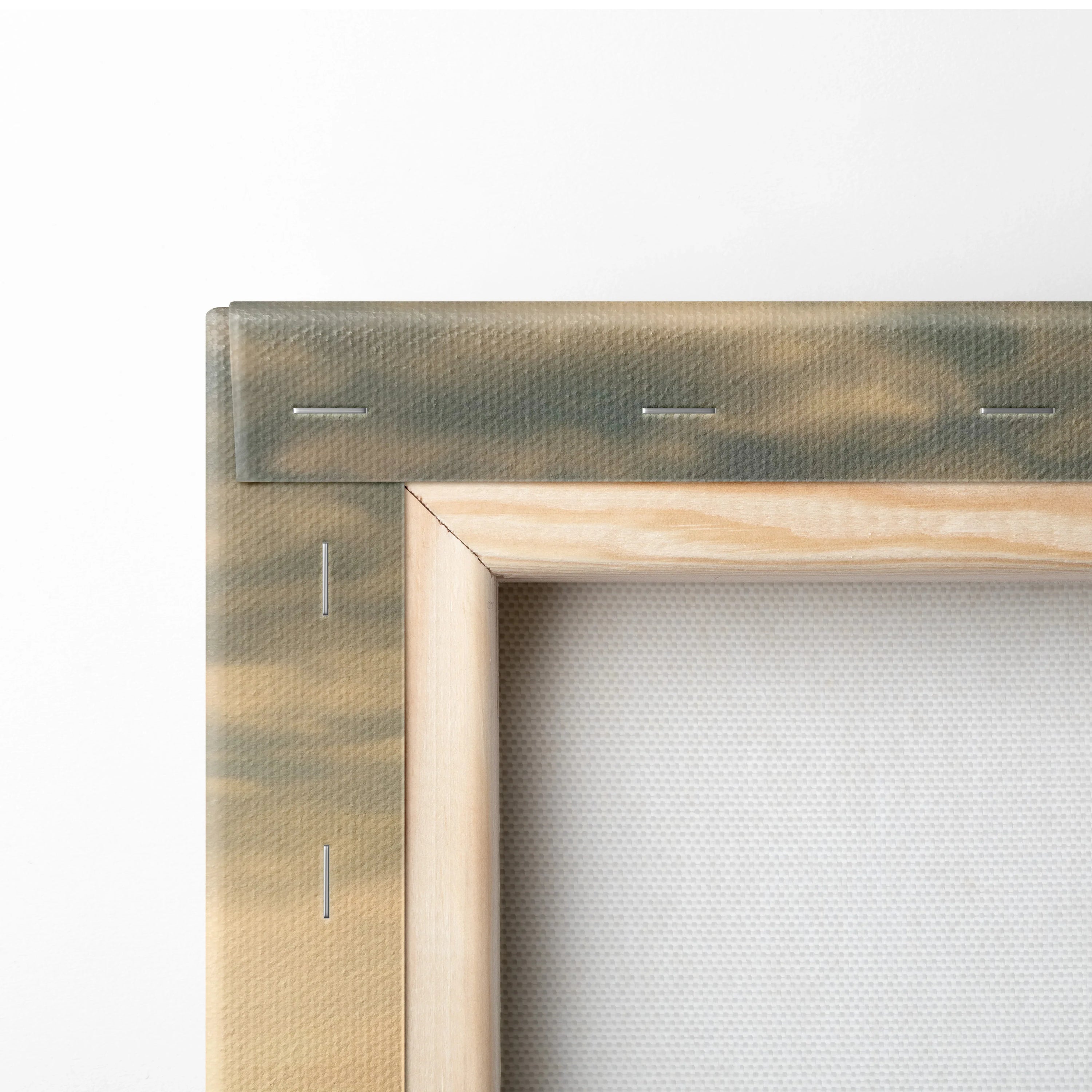 Close-up of wooden frame and stretched canvas corner with visible staples for wall art decor.