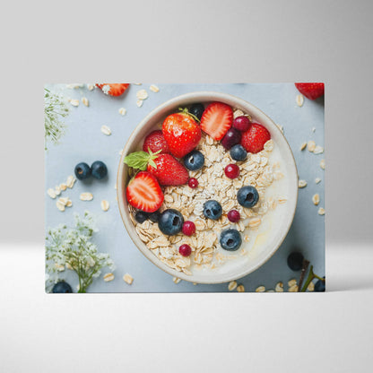 Canvas wall art depicting a breakfast bowl with granola, strawberries, blueberries, and red currants on a light blue.