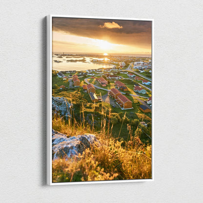 High-resolution canvas art featuring sunlit Norwegian town with red-roofed buildings and rocky landscape at sunset.