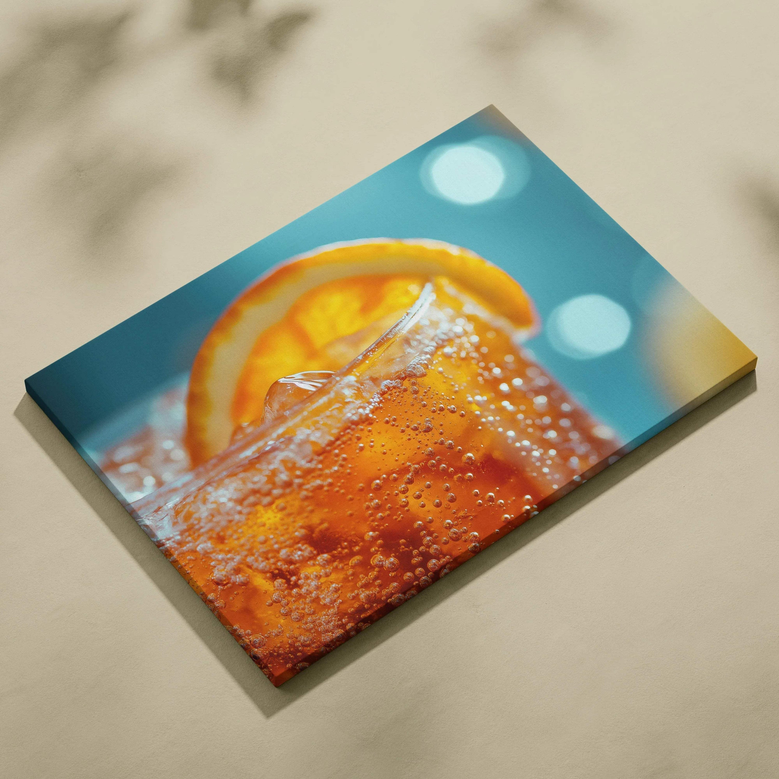 Canvas wall art featuring a close-up of an orange drink with ice cubes and a fresh orange slice against a blue background.