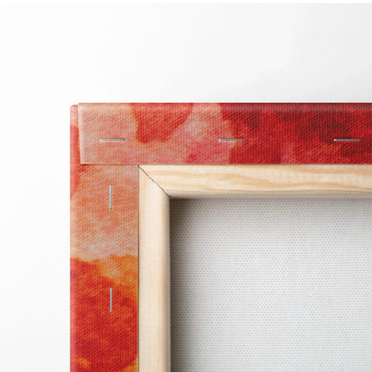 Close-up of stretched canvas corner with vibrant red and orange abstract print on wooden frame.