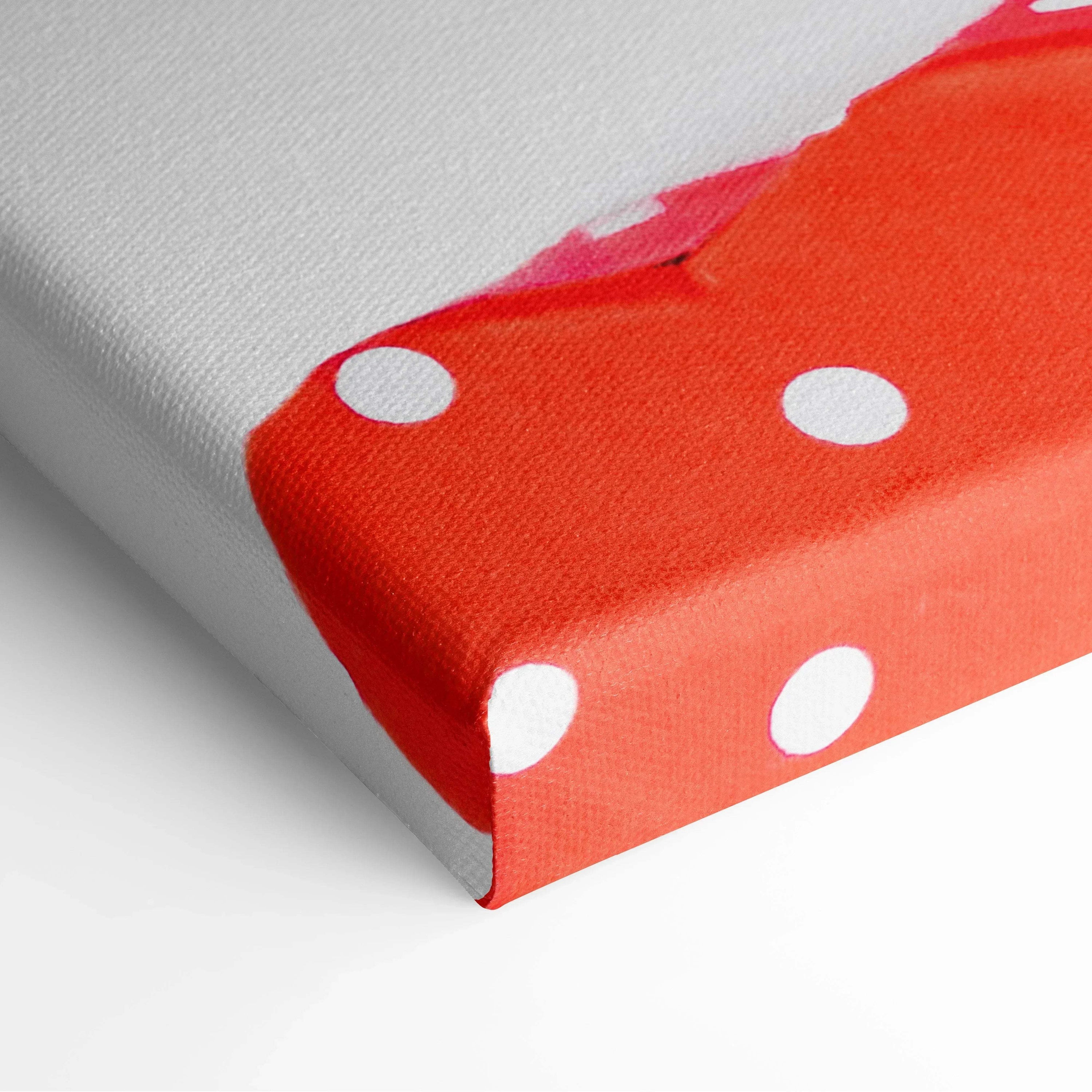 Close-up of canvas wall art corner with creamy textured red and white polka dot decor.